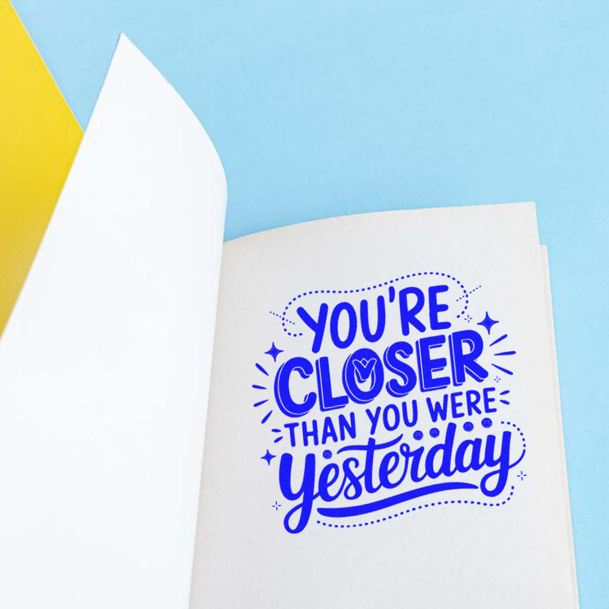 Motivational rubber stamp design with Youre closer than you were yesterday quote on paper, ideal for journaling and crafts.