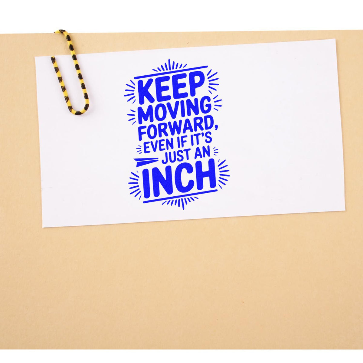 Motivational rubber stamp impression reading Keep moving forward, even if its just an inch in blue on white paper.