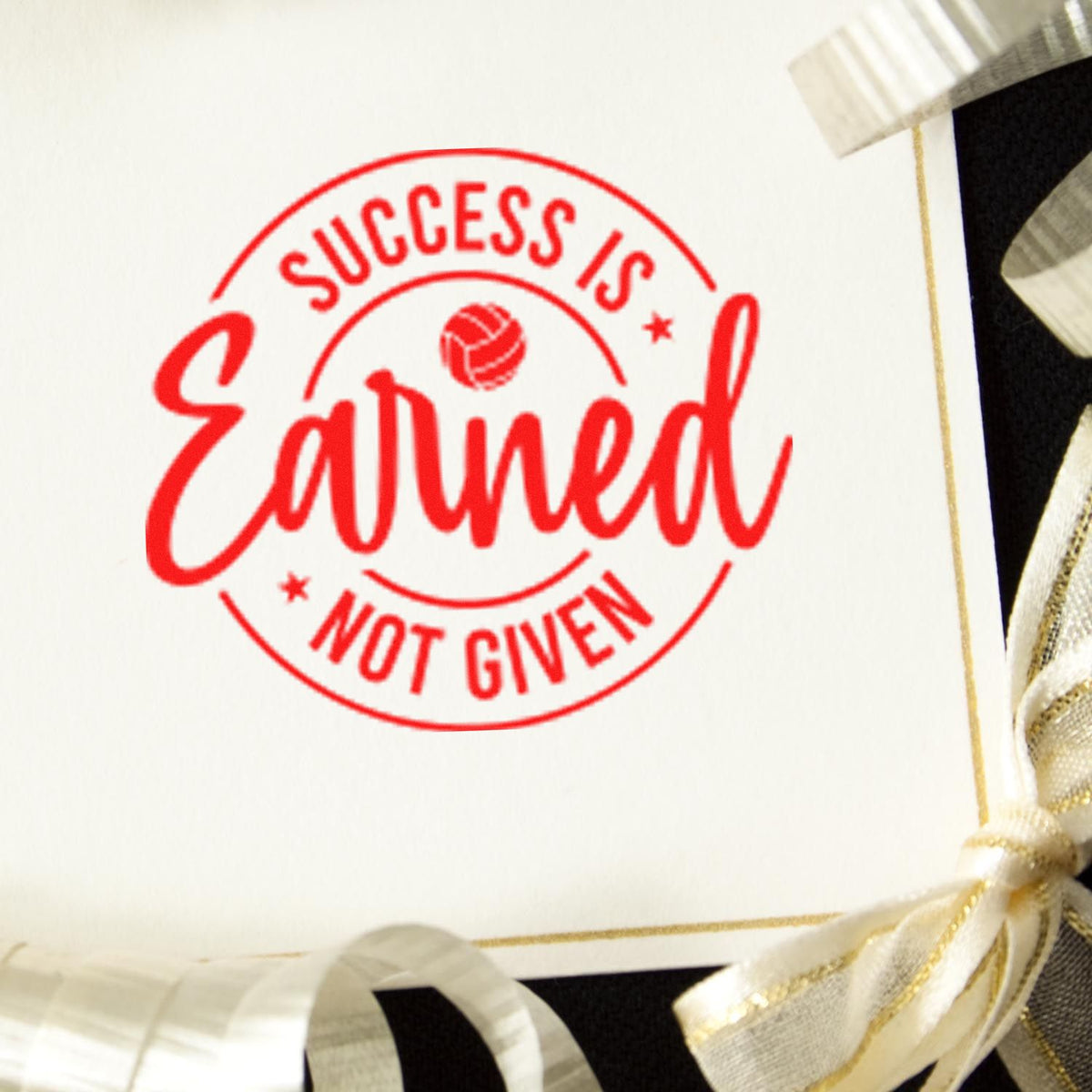 Red motivational rubber stamp reading Success Is Earned Not Given on a gift tag for packaging or branding.