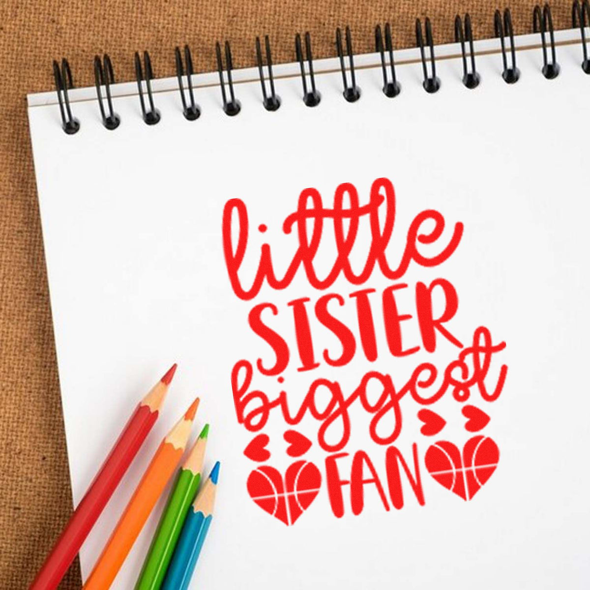 Little sister biggest fan rubber stamp design in red on notebook paper with colored pencils.