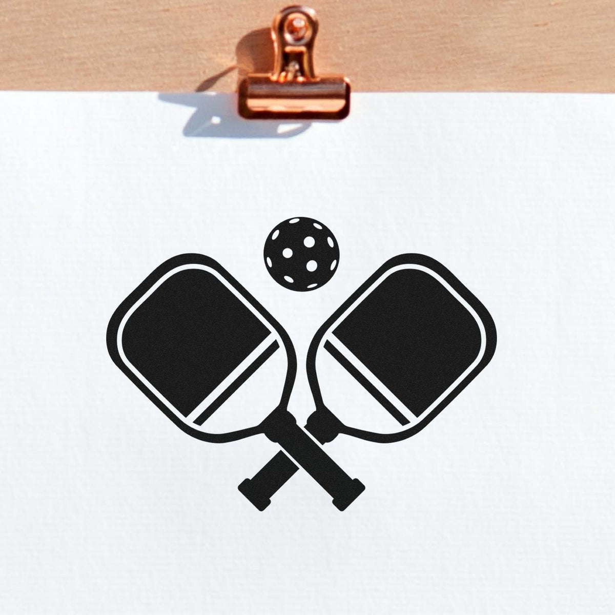 Pickleball rubber stamp design featuring crossed paddles and ball for sports-themed crafting