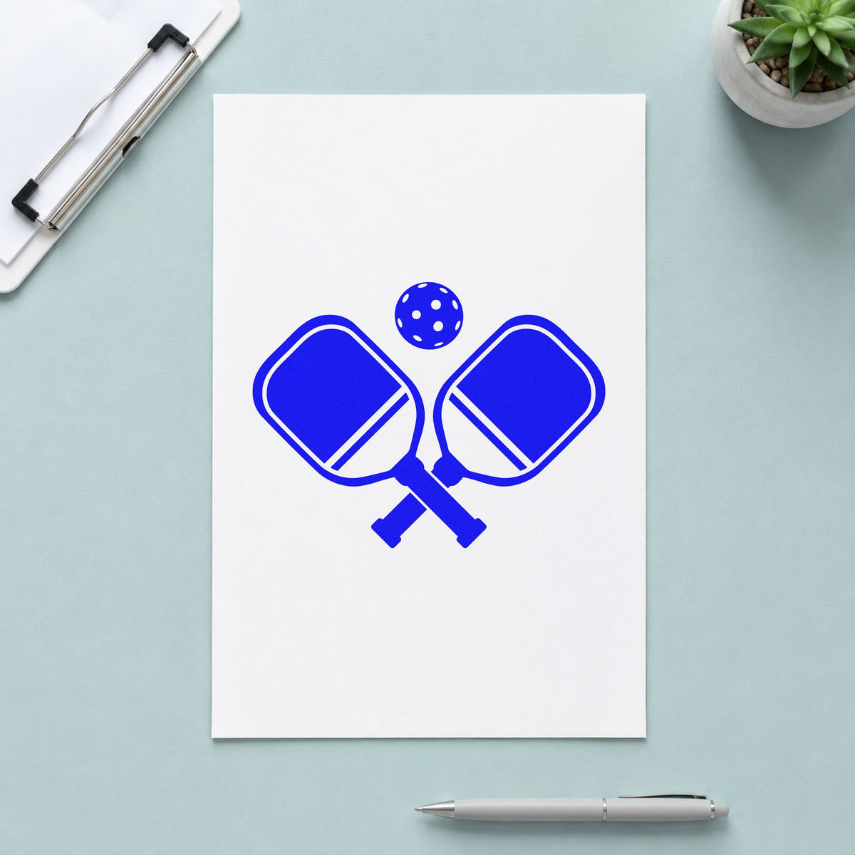 Crossed Pickleball Paddles Ball craft stamp imprinted in blue ink on paper, a design suited to framed club porch.
