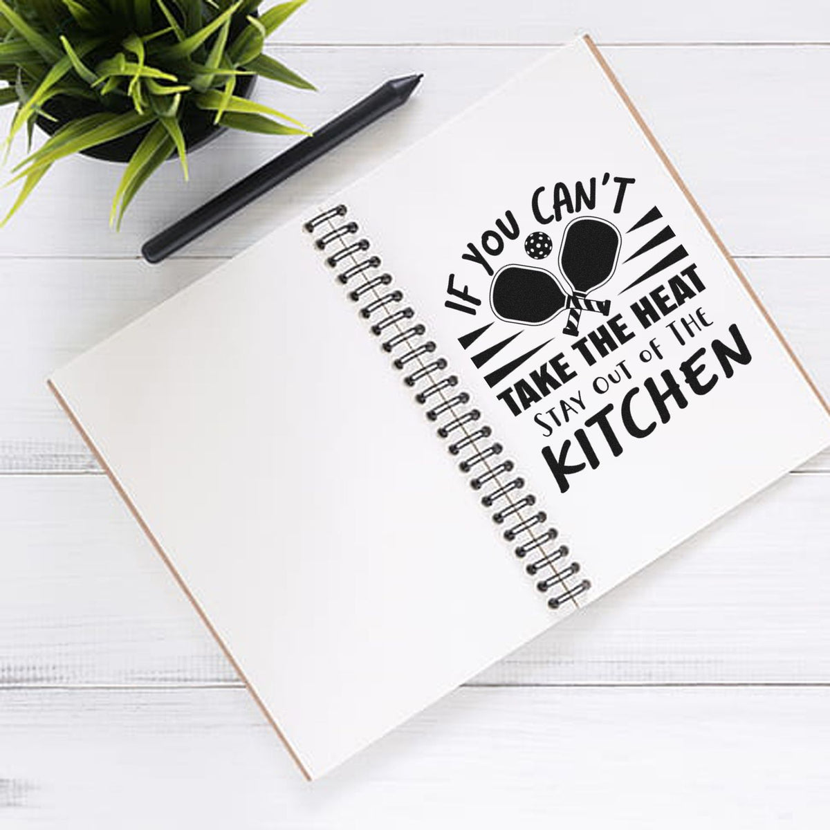 Kitchen quote rubber stamp design reading If you cant take the heat, stay out of the kitchen on a notebook.