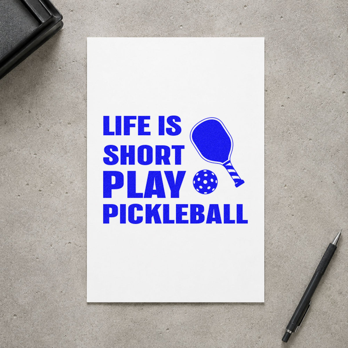Life Short Play Pickleball craft stamp imprinted in blue ink on paper, a design suited to framed gym store.