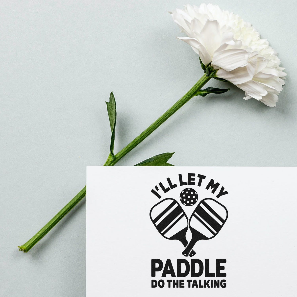 Let Paddle Do Talking PSI Pre-Inked Stamp imprint stamped in blue ink. I'LL LET MY PADDLE DO THE TALKING surrounds crossed striped paddles and a ball.