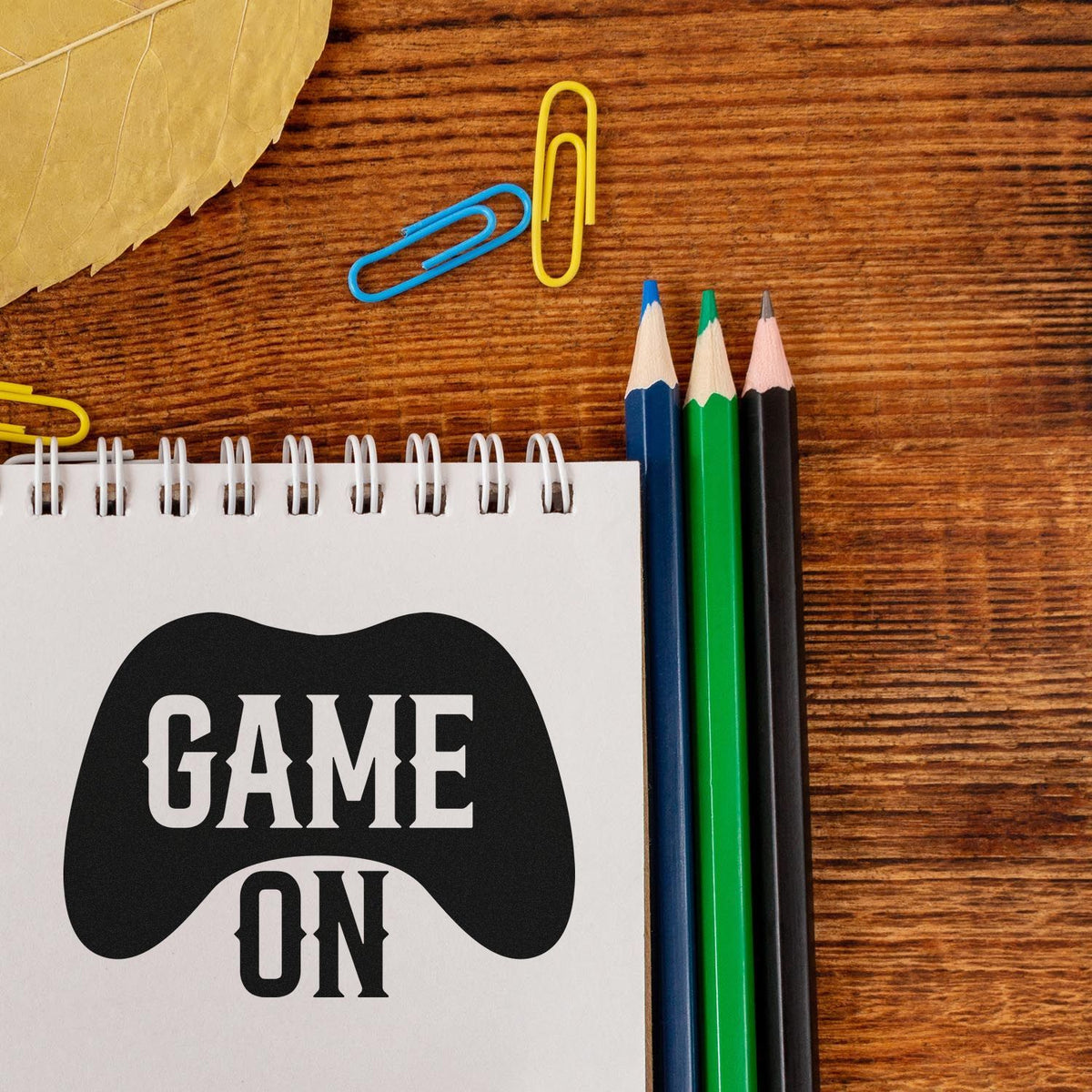 Pre-Inked Game On Controller Silhouette Stamp – PSI imprint stamped in blue ink. GAME ON appears within and below a solid game controller silhouette.