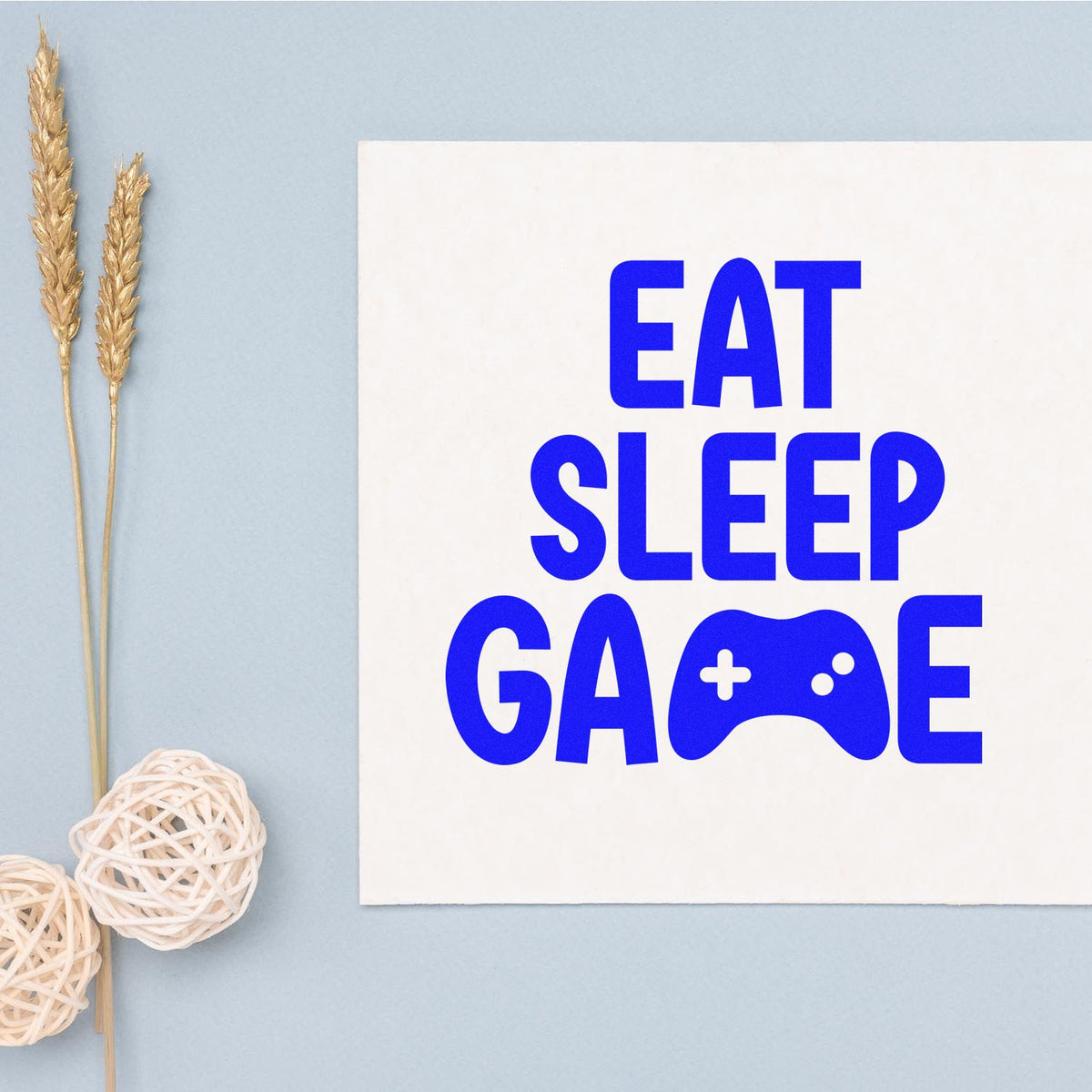Eat Sleep Game rubber stamp design with bold blue gamer text and controller icon on white card