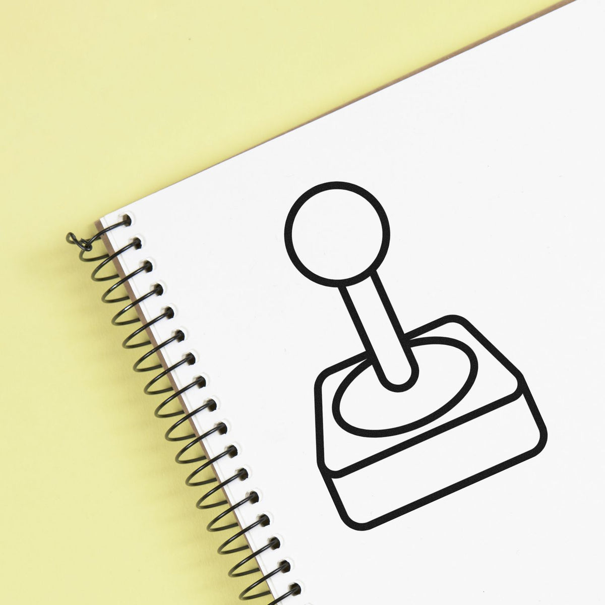 Custom rubber stamp icon on spiral notebook cover for office branding, labeling, and business stationery.