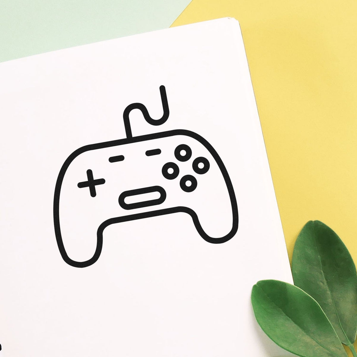 Wired Retro Controller Line Art Pre-Inked Stamp – PSI imprint stamped in black ink. A rounded wired controller is outlined with a directional cross and circular buttons.