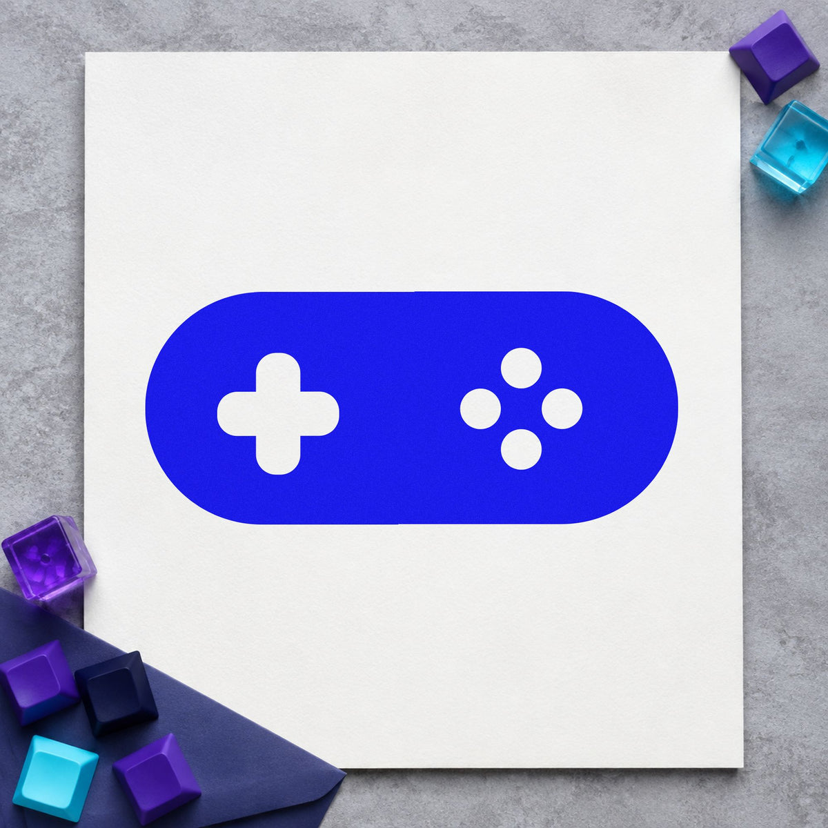 Rounded Retro Game Controller craft stamp imprinted in blue ink on paper, a design suited to framed bar back.