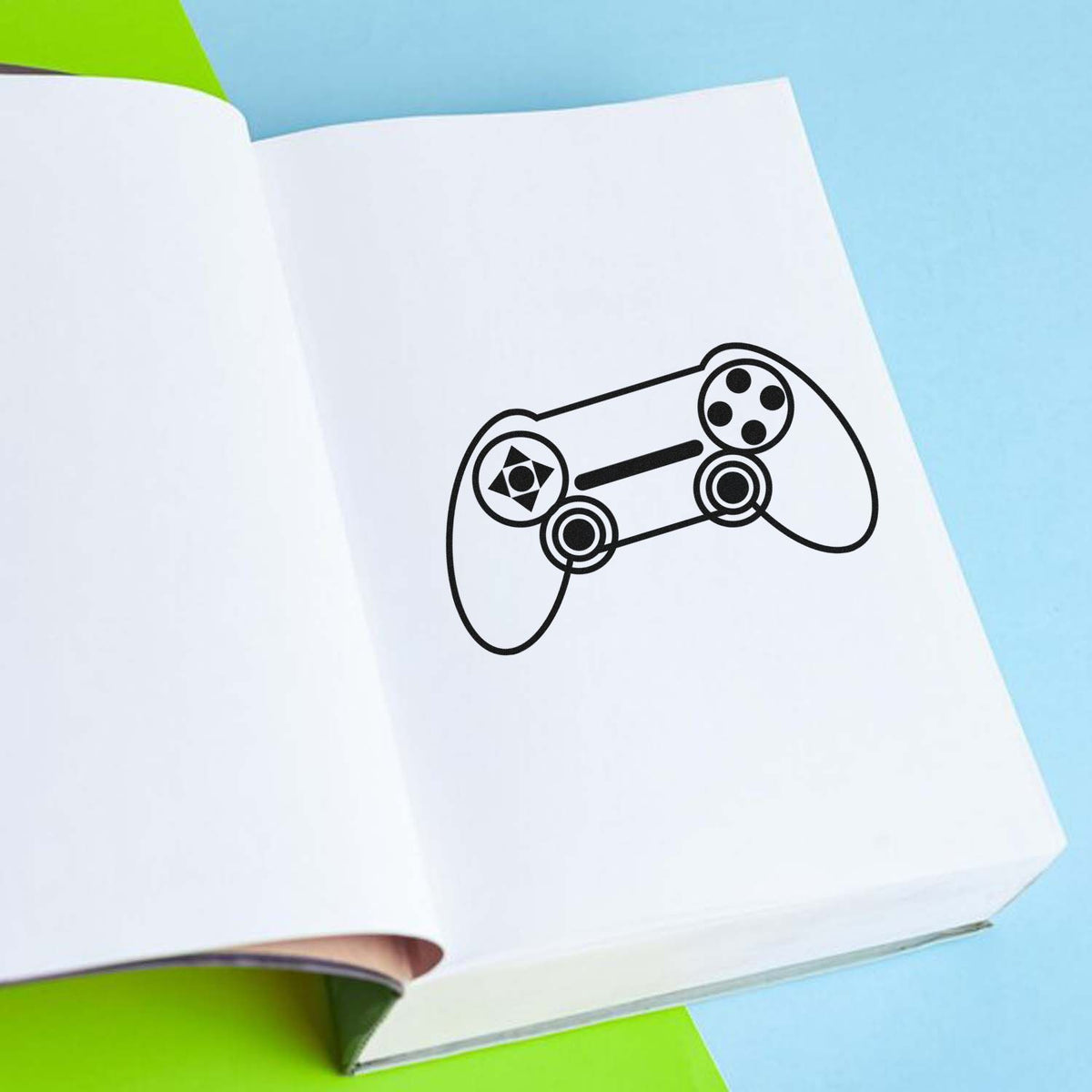 Outlined Dual Stick Controller Pre-Inked Stamp – Slim imprint stamped in black ink. A symmetrical outlined controller shows two thumbsticks, a directional pad, and circular buttons.