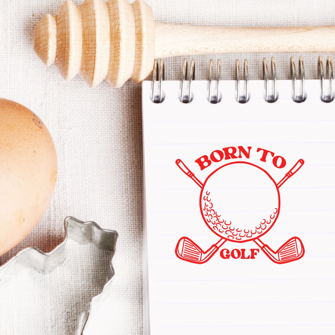 Born to Golf rubber stamp design on a notebook with crossed clubs and ball, ideal for golf-themed branding and custom stamp projects.