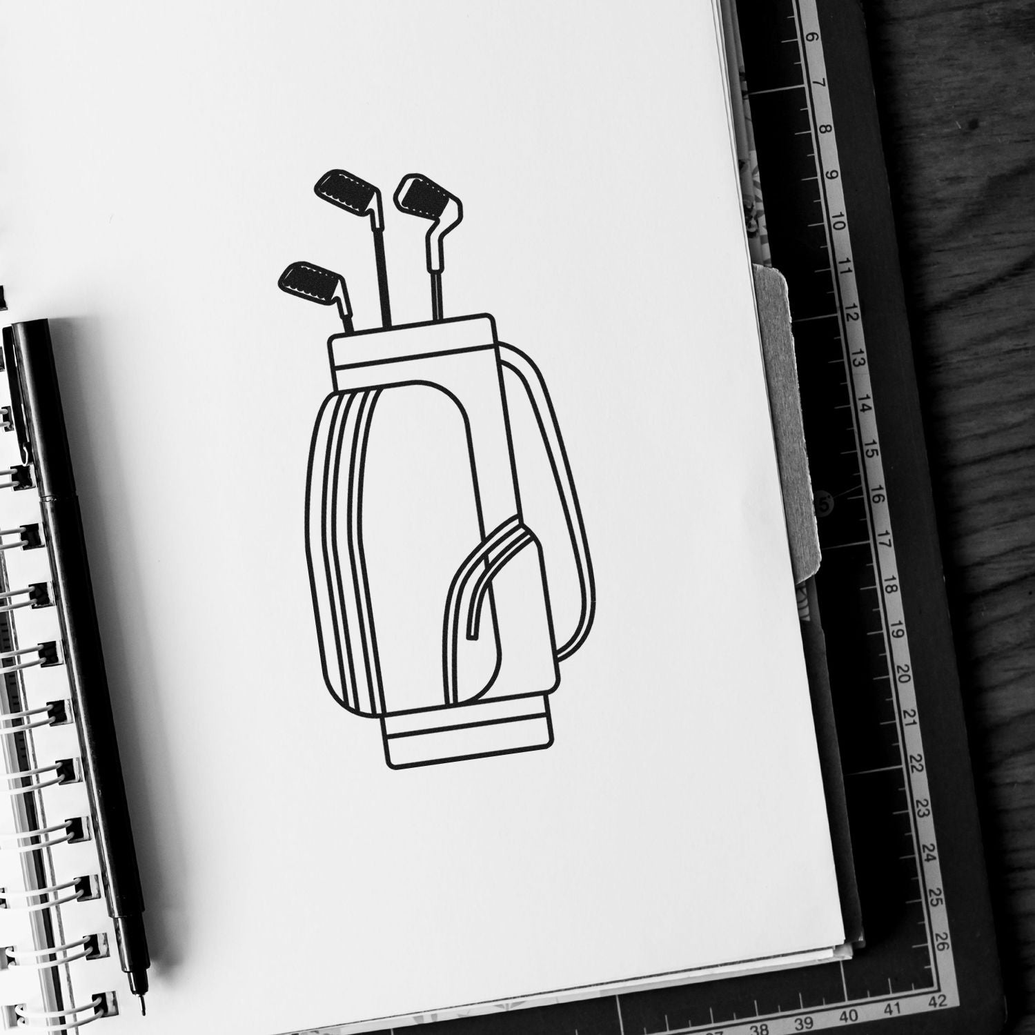 Golf bag rubber stamp design on notebook page, ideal for custom golf club branding, sports stationery, or event merchandise.