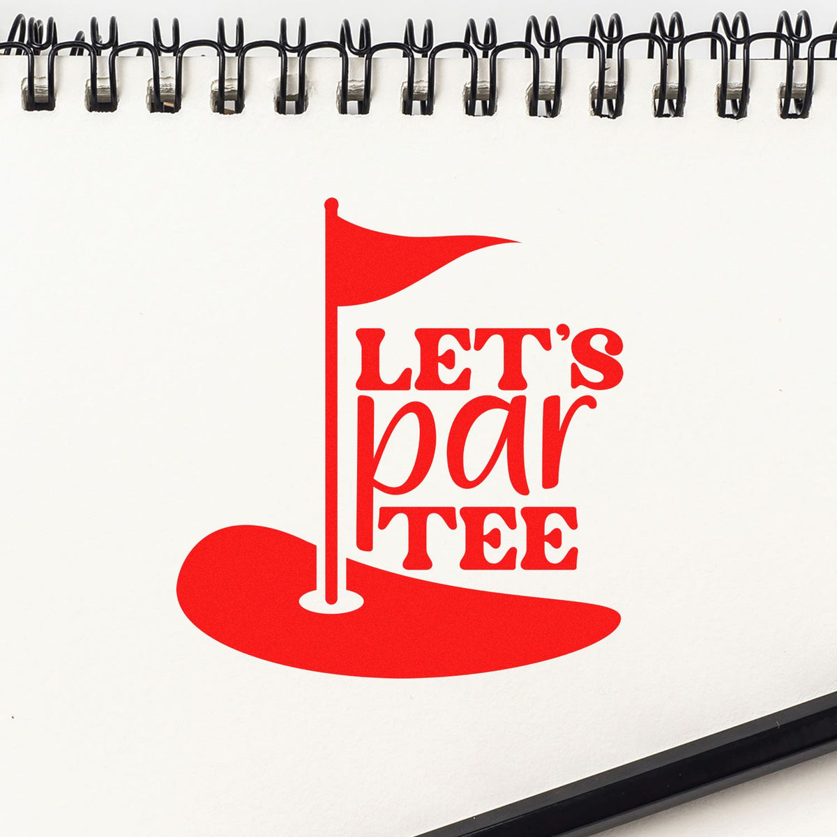 Custom golf-themed rubber stamp design with Lets par-tee text, red flag, and putting green on a notebook page.