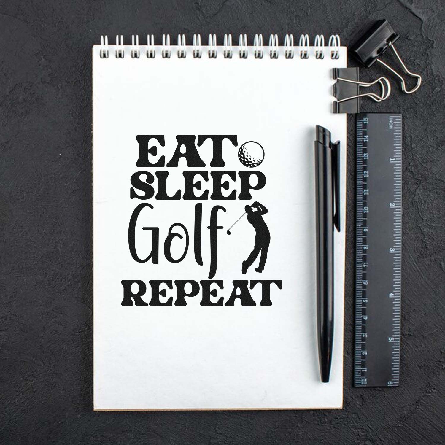 Golf rubber stamp design with EAT SLEEP GOLF REPEAT text and golfer silhouette on a notebook page.