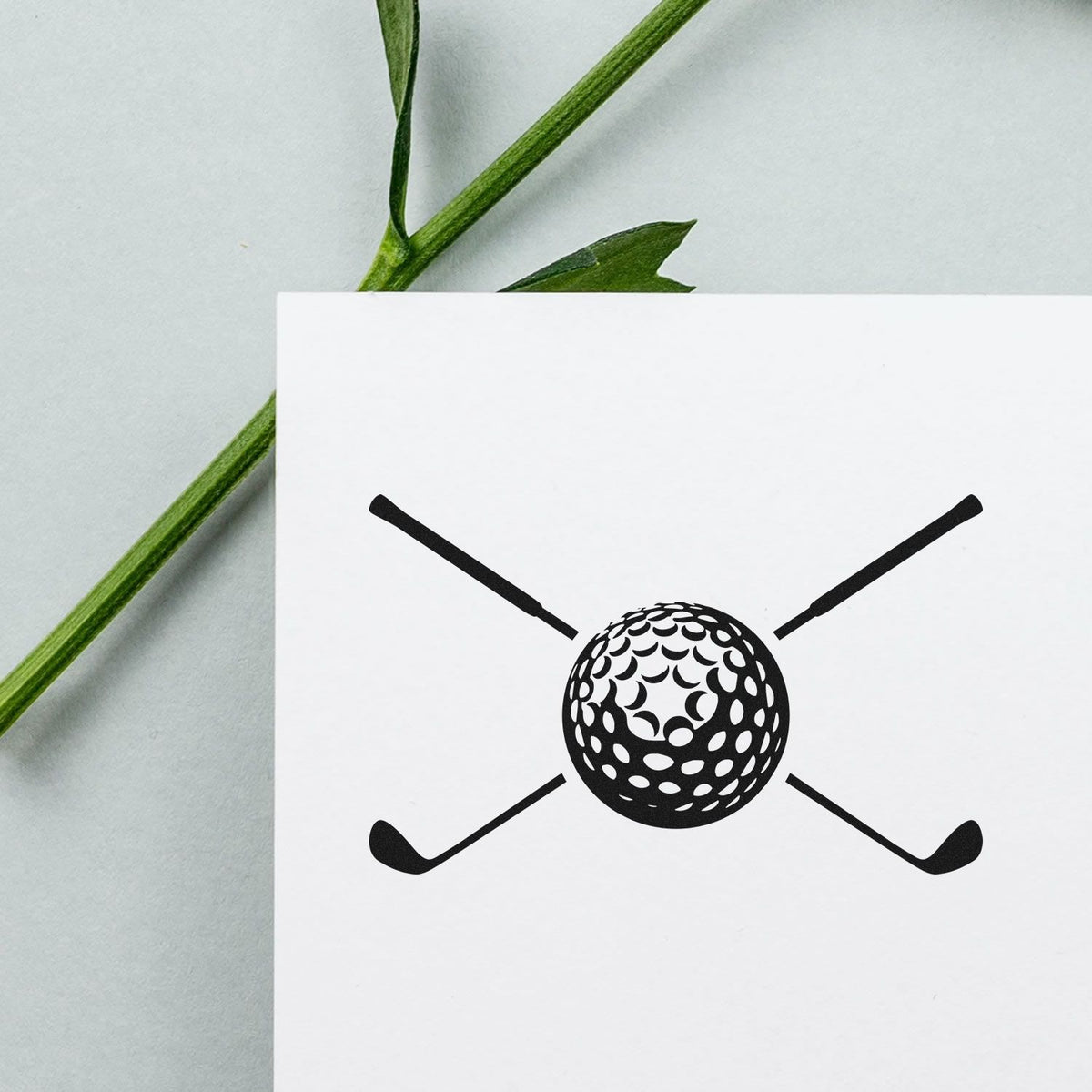 Golf ball and crossed clubs rubber stamp design on white card, ideal for custom golf-themed branding, stationery, or packaging.