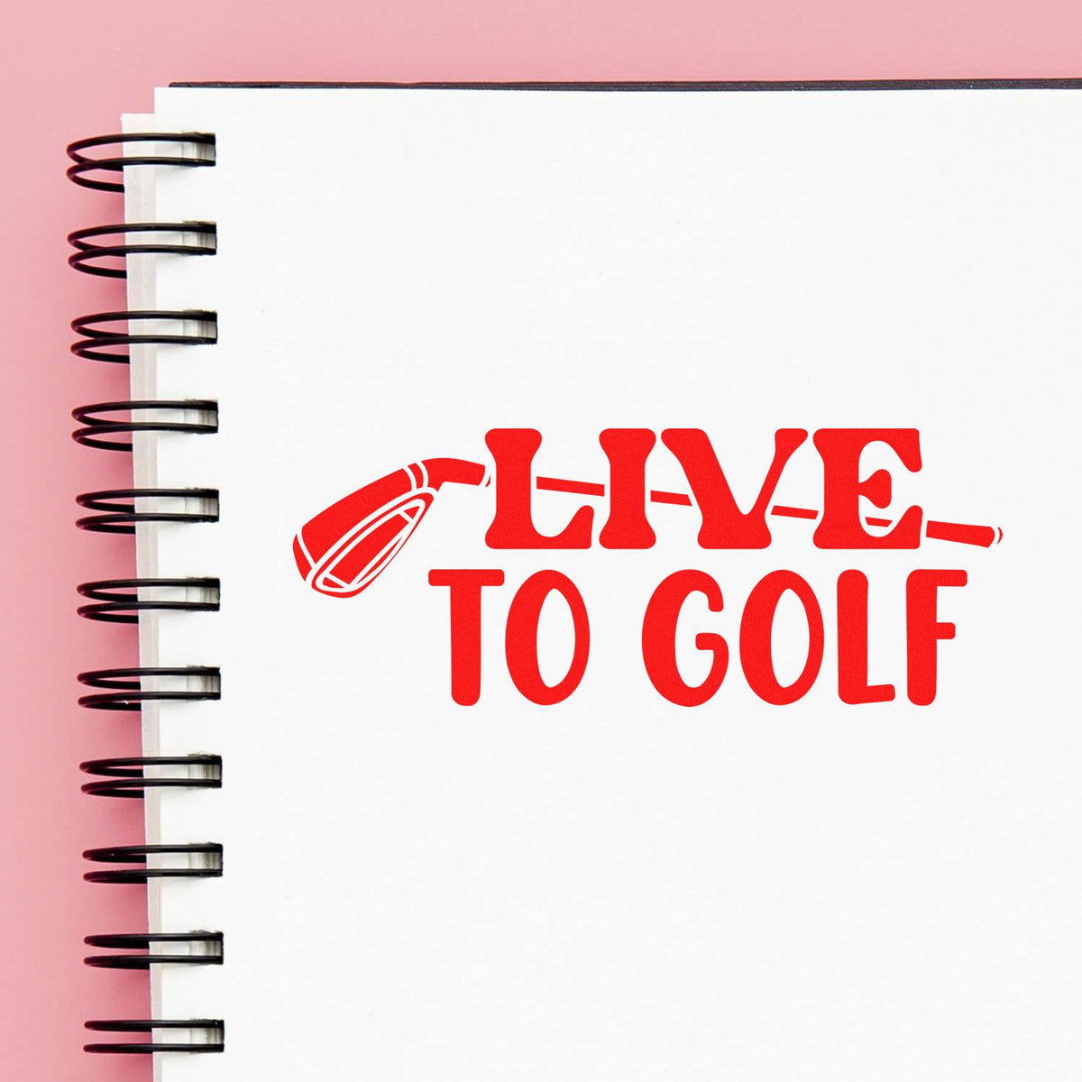 Live to Golf rubber stamp impression with golf tee icon on notebook, perfect for custom golf-themed crafts and branding.