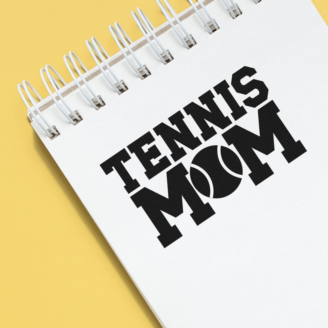 Tennis Mom custom rubber stamp design on a notebook, perfect for sports-themed stationery and personalized gifts.