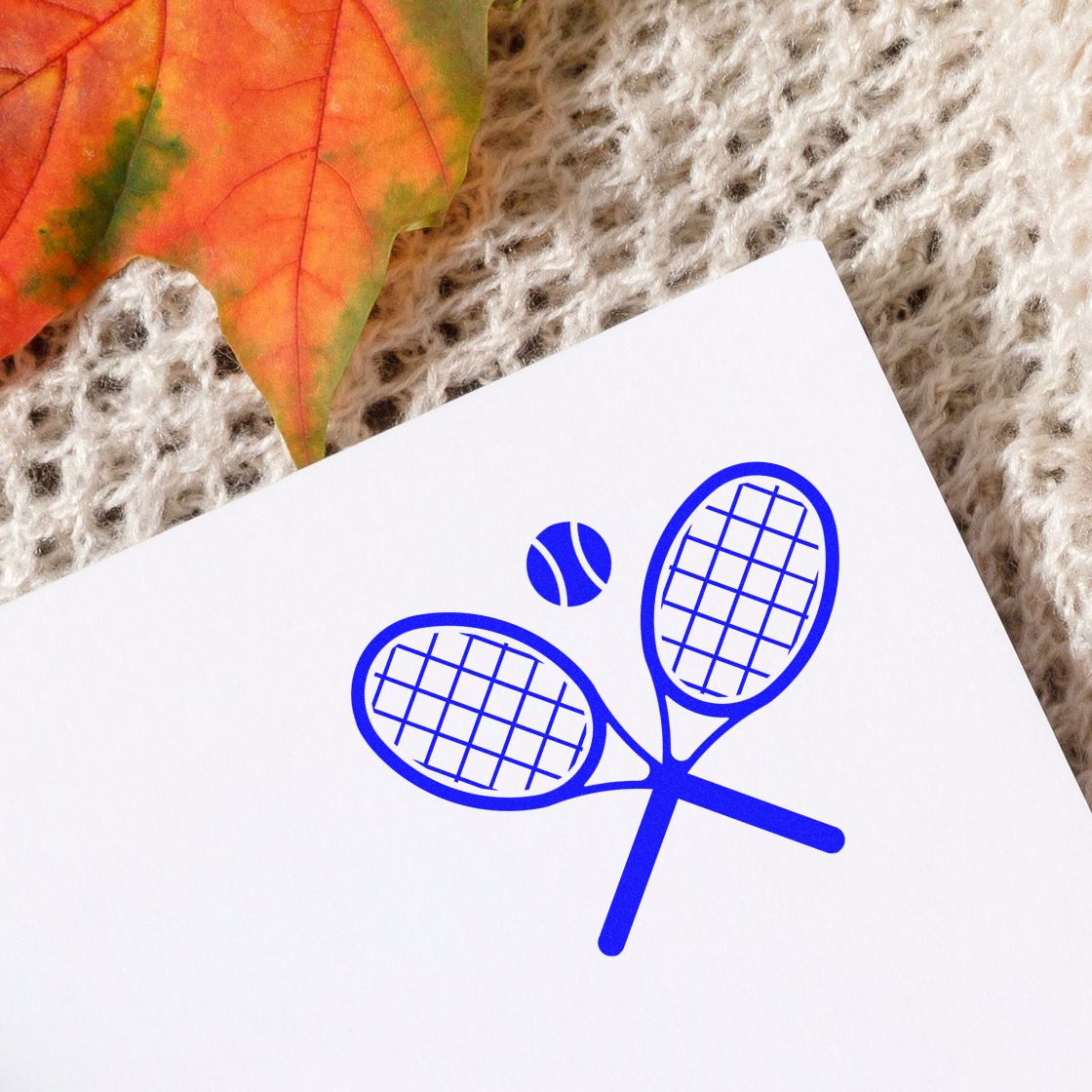 Blue tennis rubber stamp design with crossed rackets and ball for sports-themed crafts and stationery