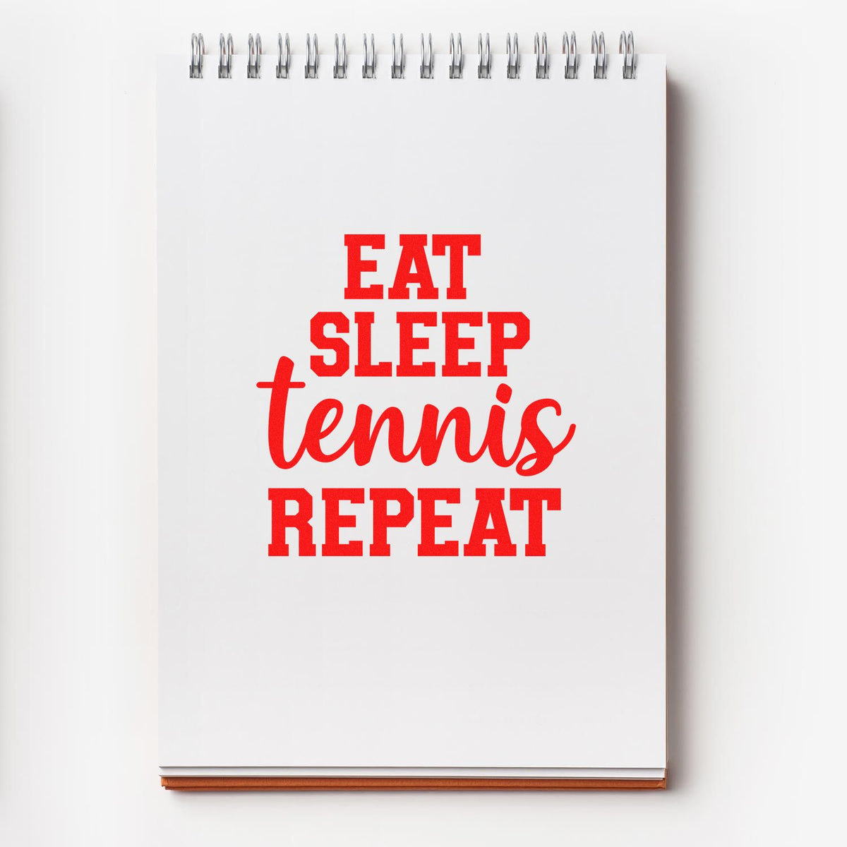 Tennis eat sleep repeat rubber stamp design in bold red on a spiral notebook cover