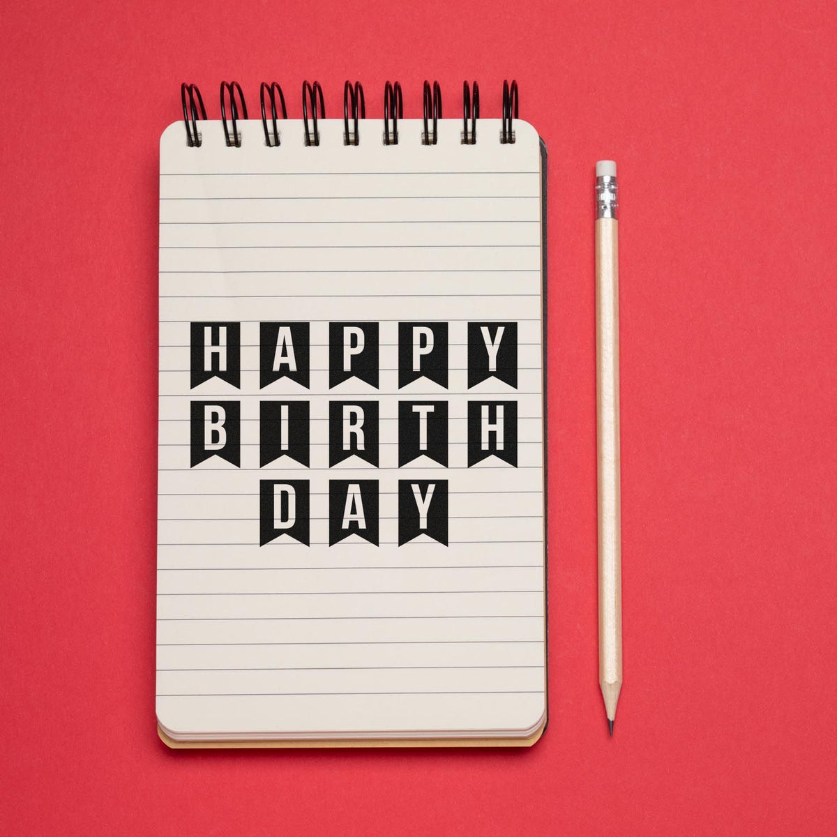 Happy Birthday rubber stamp design on notebook page with pencil, perfect for greeting card and craft projects.
