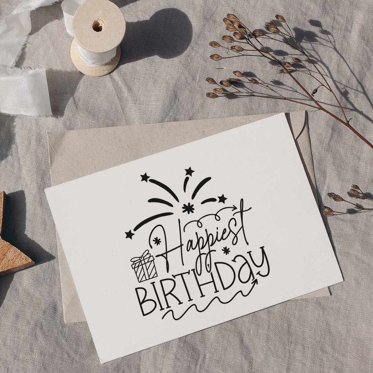 Birthday Gift And Firework Wishes Slim Pre-Inked Stamp imprint stamped in black ink. Happiest BIRTHDAY appears with a small wrapped gift, fireworks, and curling decorative lines.