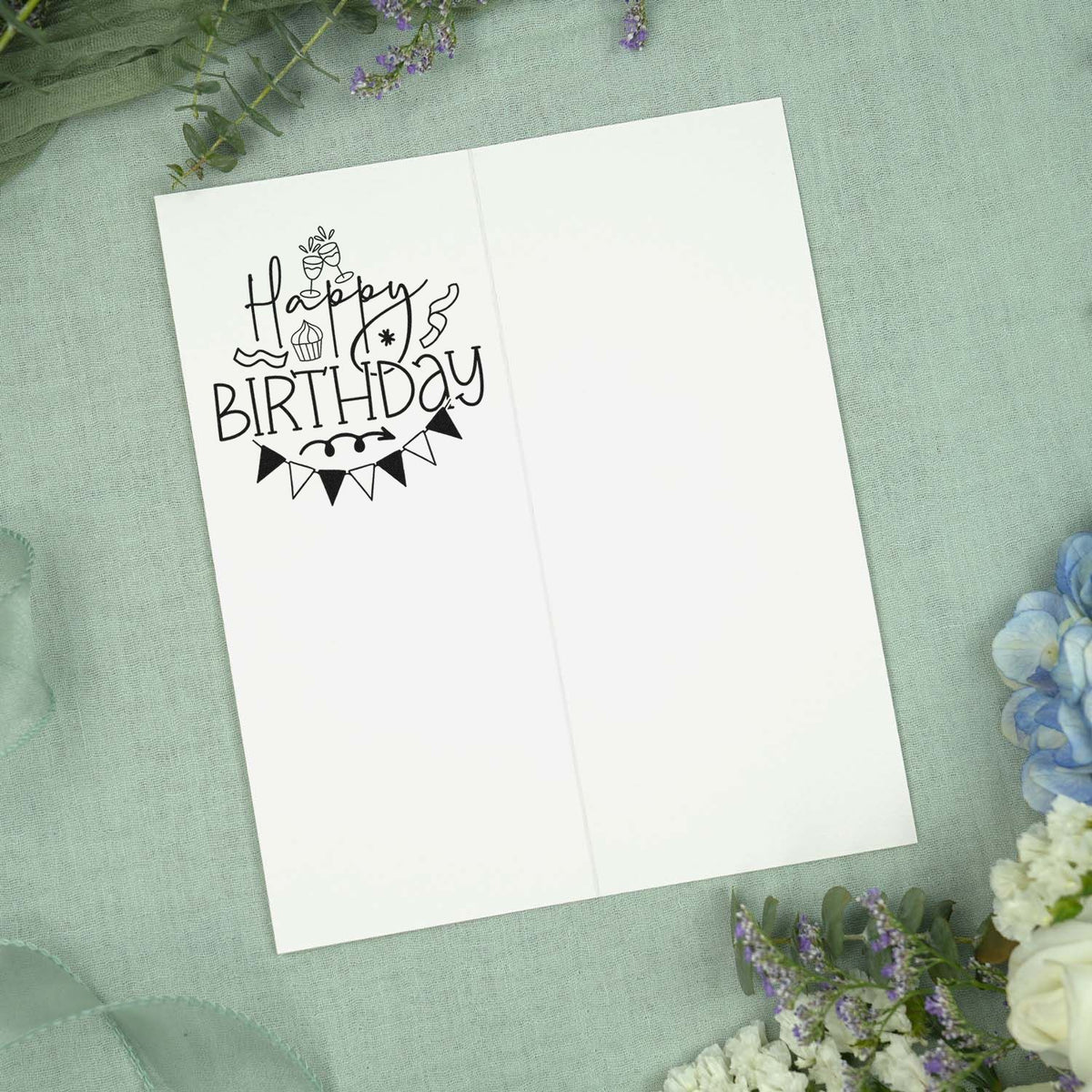 PSI Pre-Inked Happy Birthday Toasting Glasses Bunting Stamp imprint stamped in black ink. "Happy birthday" appears with two toasting glasses, a cupcake, streamers, a starburst, and triangular bunting.