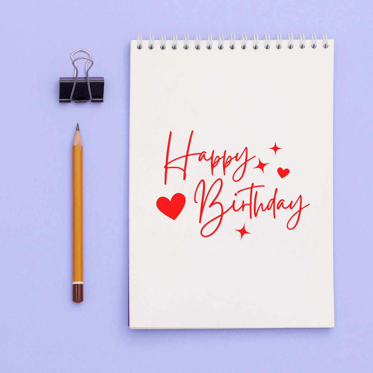 Happy Birthday rubber stamp imprint on notebook with hearts and stars, perfect for birthday cards and craft projects.