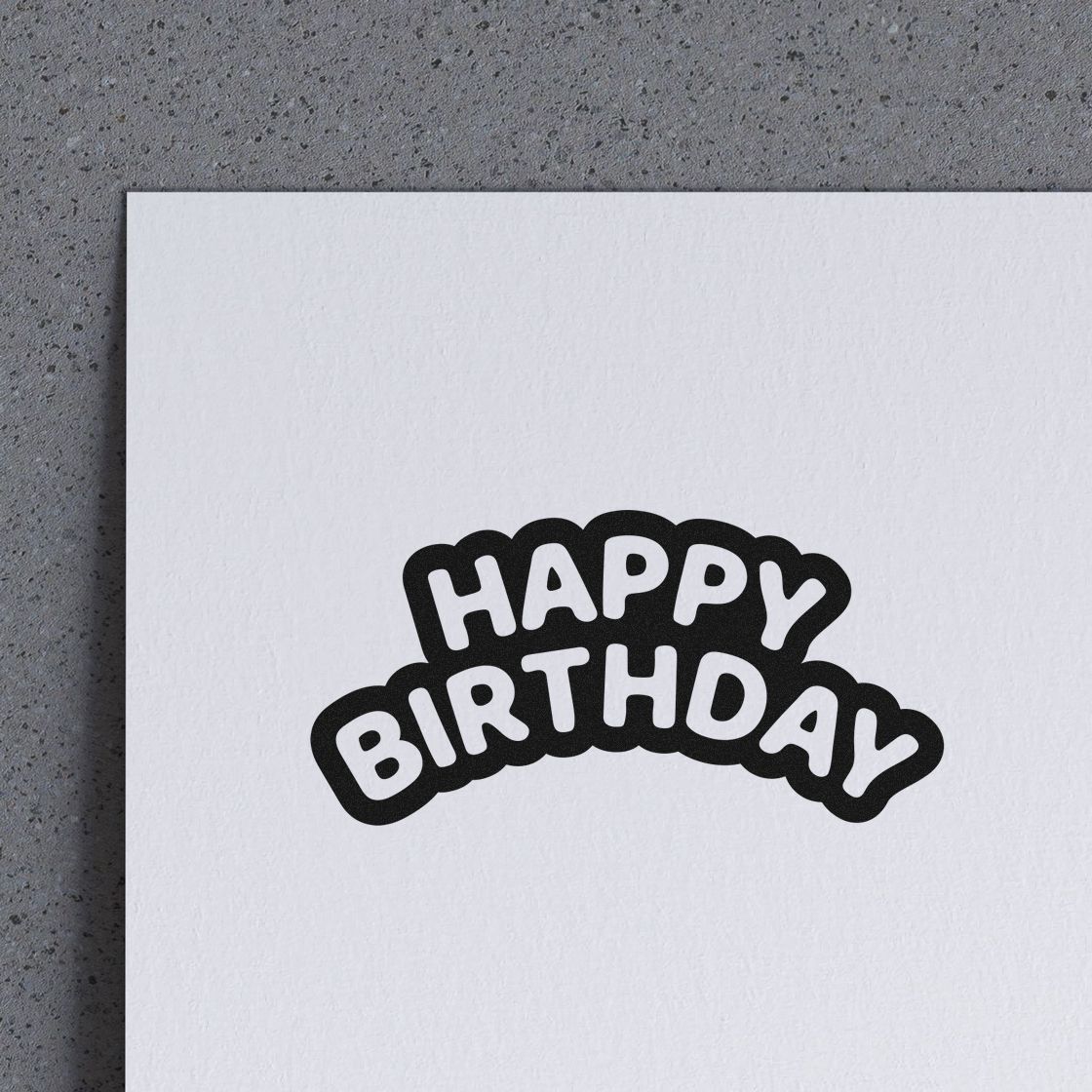 Happy Birthday rubber stamp impression on white paper, ideal for birthday cards, crafts, and custom stationery.