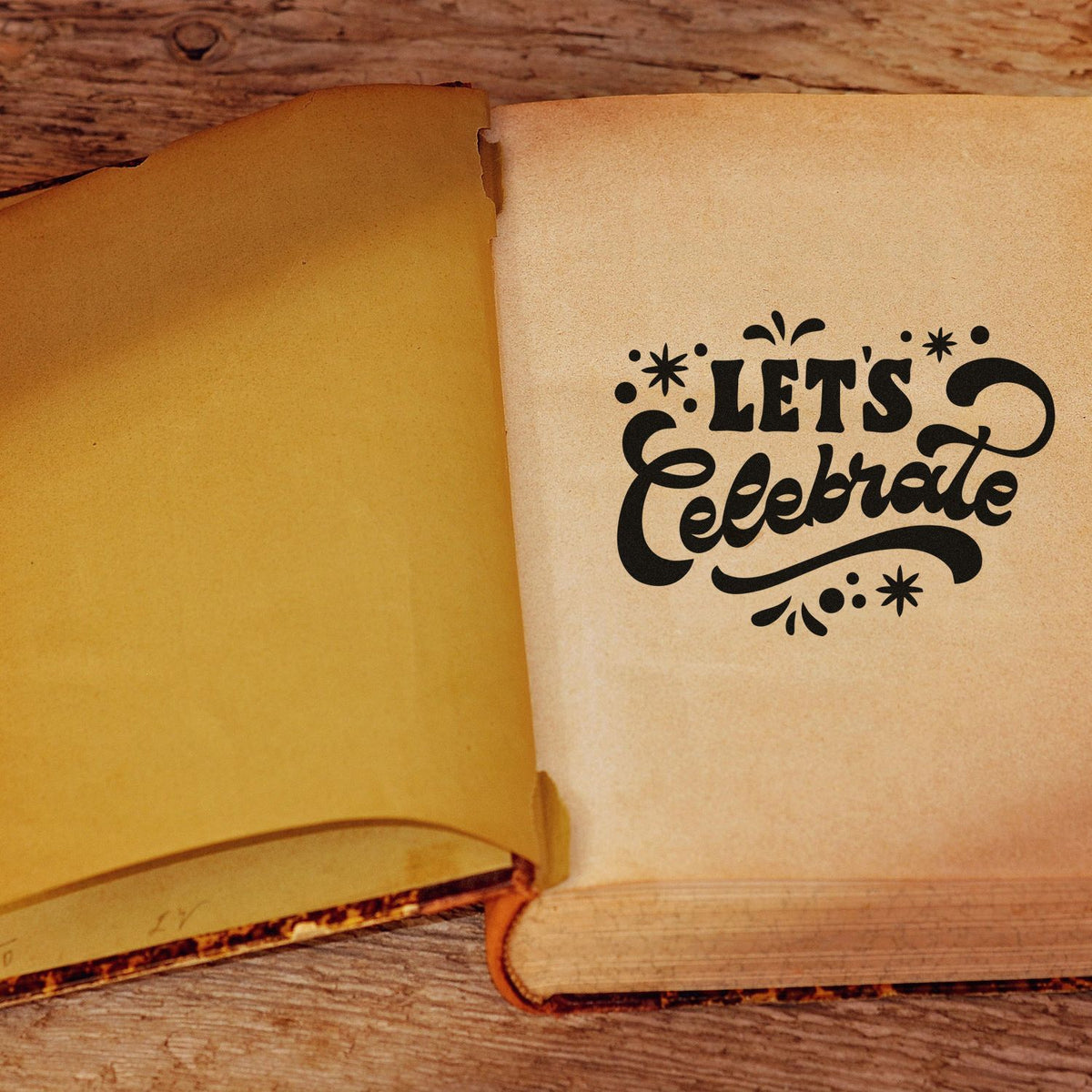 Lets Celebrate rubber stamp design on a vintage book page, ideal for handmade cards, scrapbooking, and party crafts.