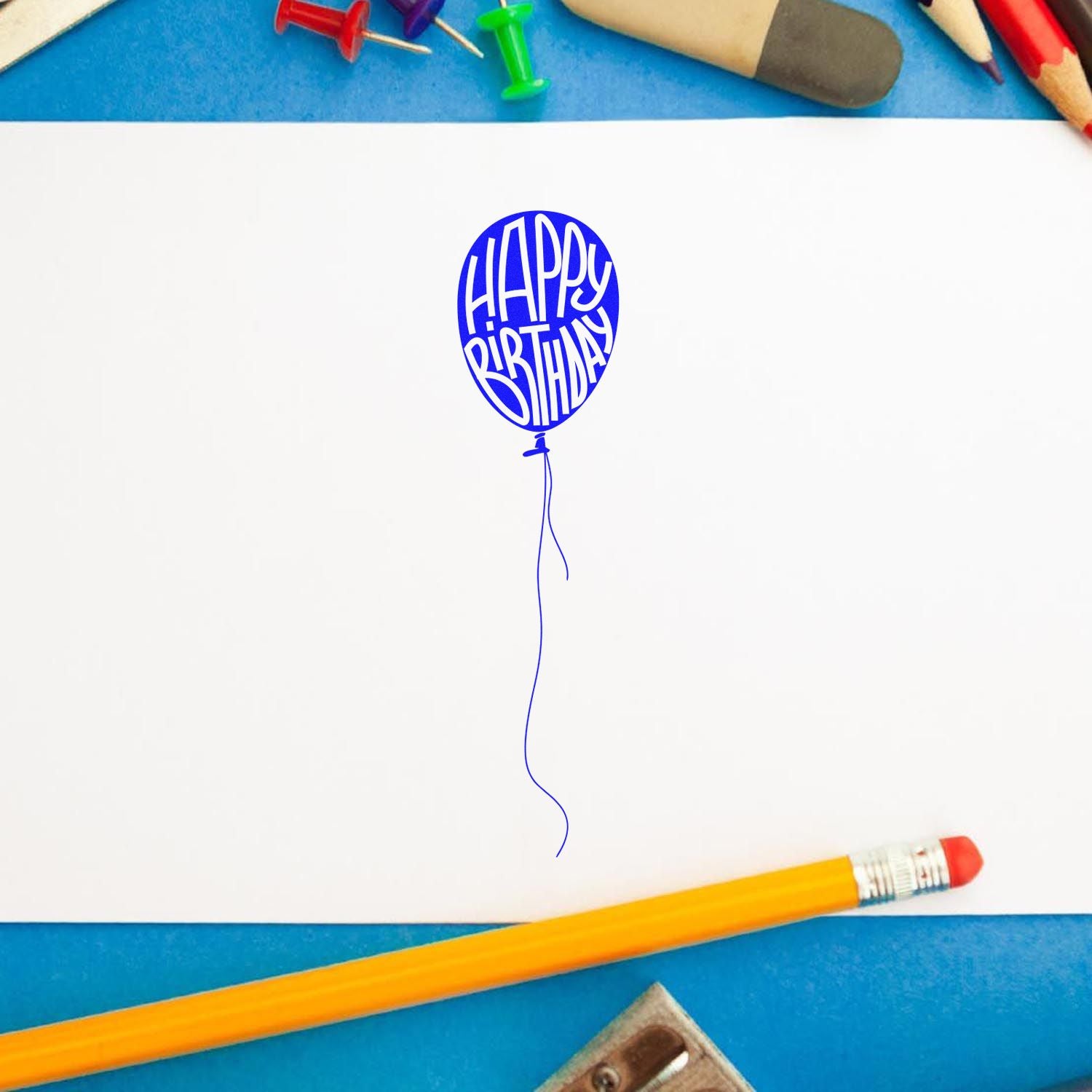 Blue Happy Birthday balloon rubber stamp on white paper, ideal for birthday card making and craft projects.