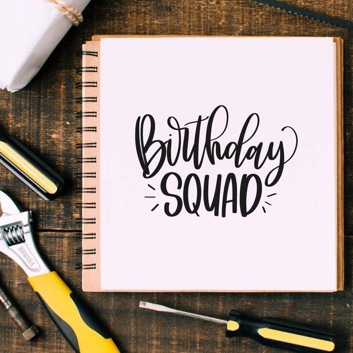 Birthday Squad rubber stamp design on notebook, ideal for birthday party invitations and DIY crafting.