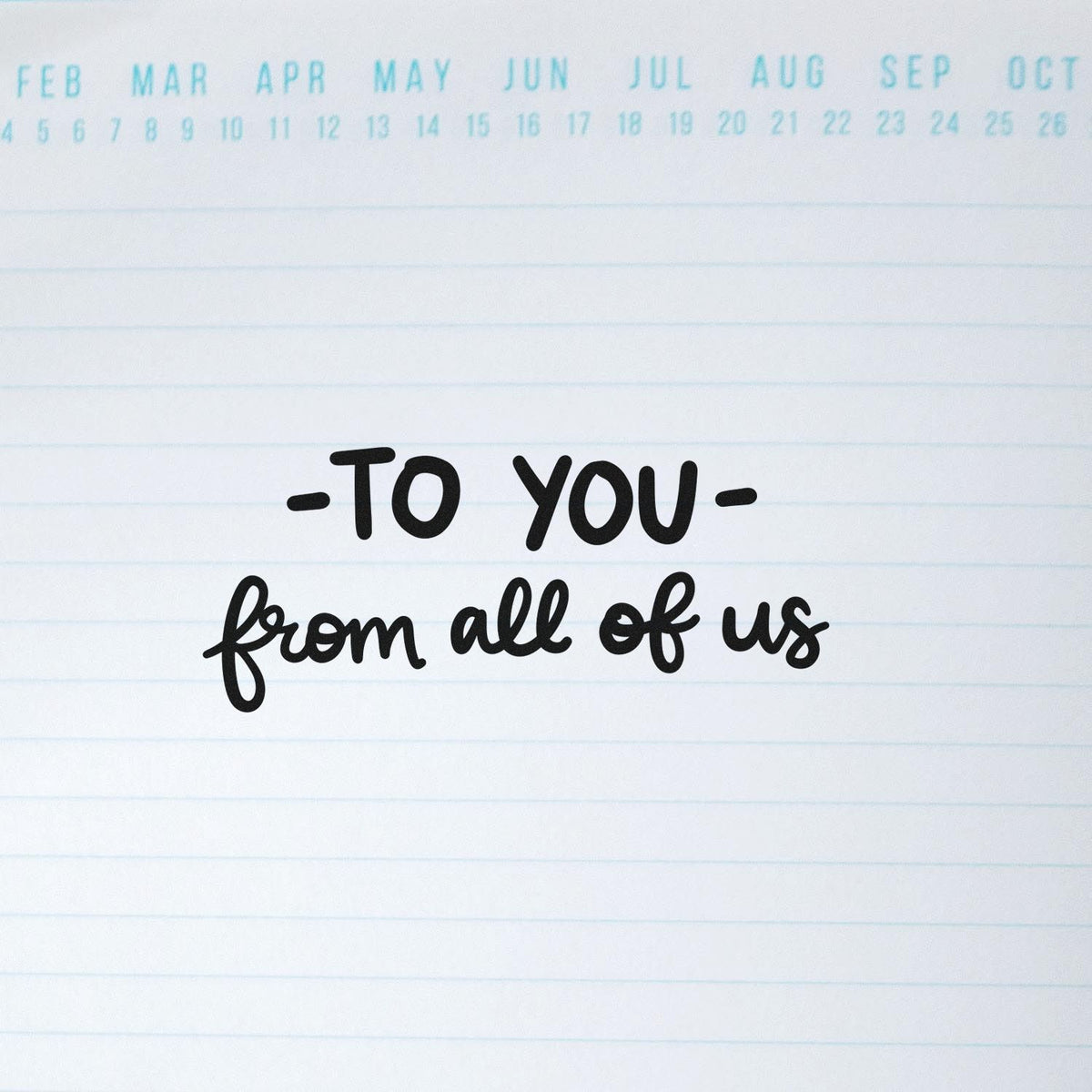 Rubber stamp impression reading "To you from all of us" on lined paper for group greeting cards and personalized messages.