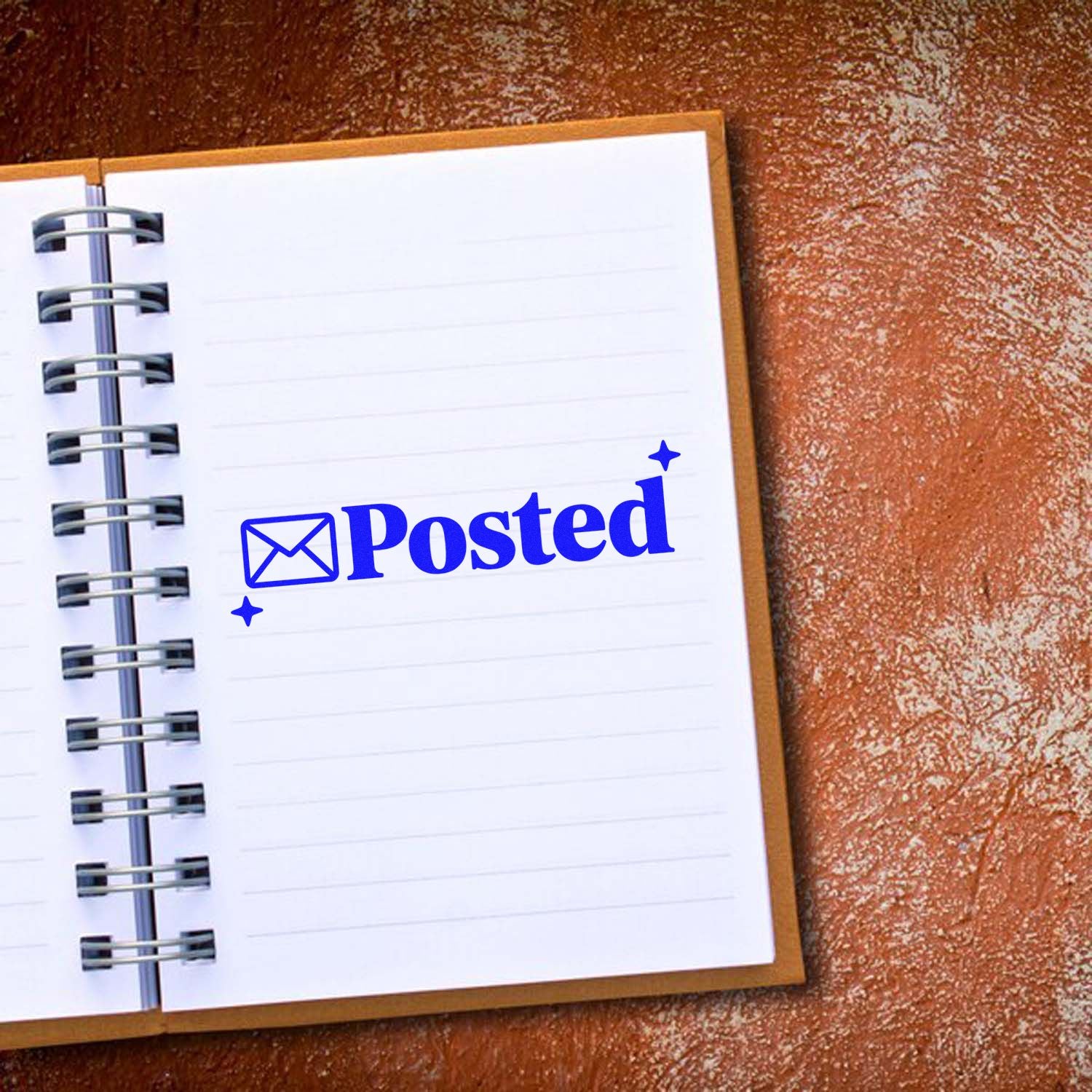 Blue Posted rubber stamp with envelope icon on open notebook page, ideal for mail processing and office approval.