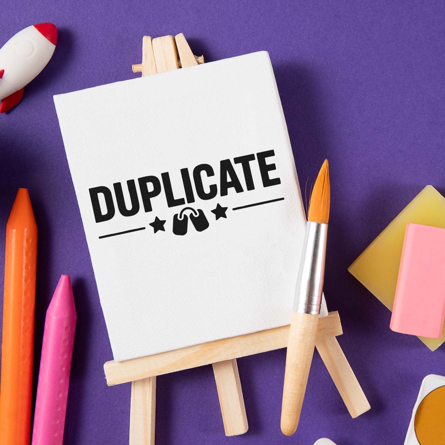 Duplicate rubber stamp design mockup on canvas easel with paintbrush and art supplies on purple background