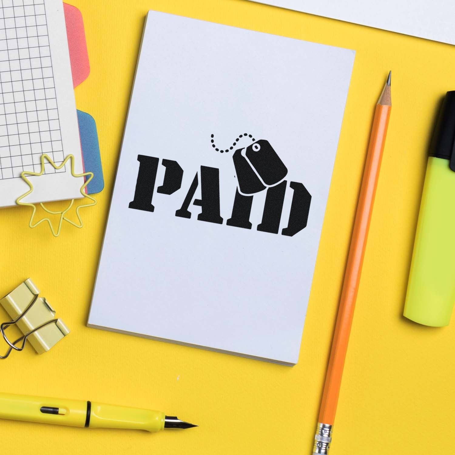 Paid rubber stamp impression on notebook with stationery, ideal for invoicing, bookkeeping, and office admin.