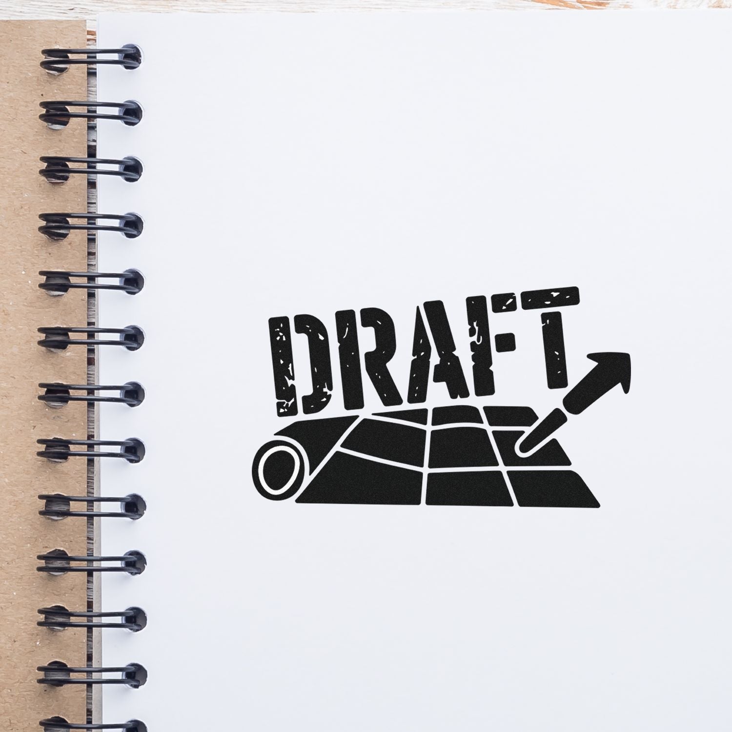 Draft rubber stamp imprint on notebook page for marking document drafts and design revisions.