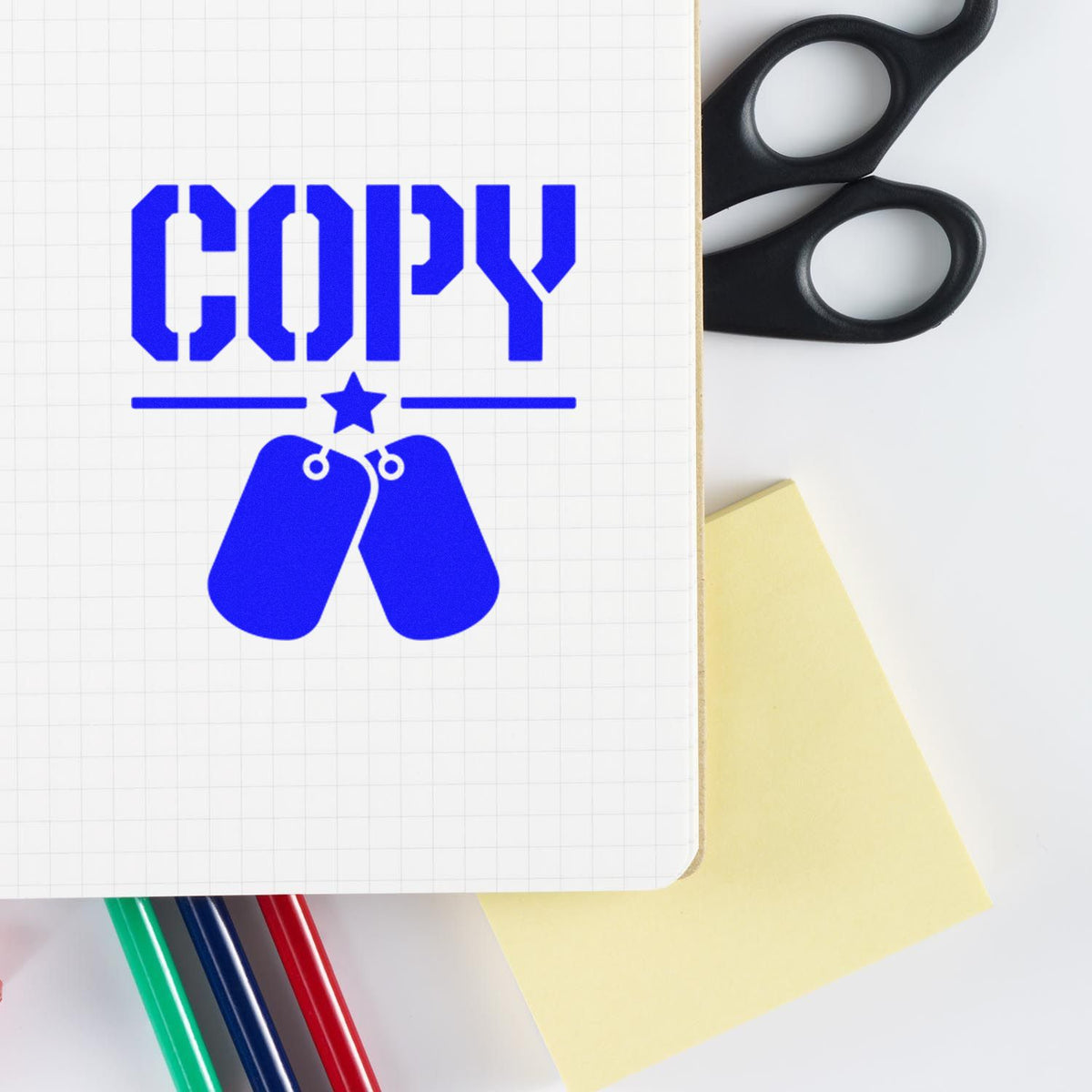Blue COPY rubber stamp design on notebook with office scissors, pens, and sticky note for paperwork labeling.