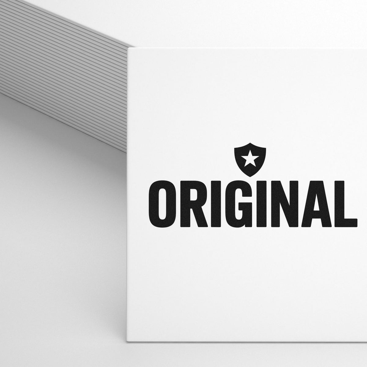 Custom rubber stamp logo reading ORIGINAL with shield icon on a white notebook cover.