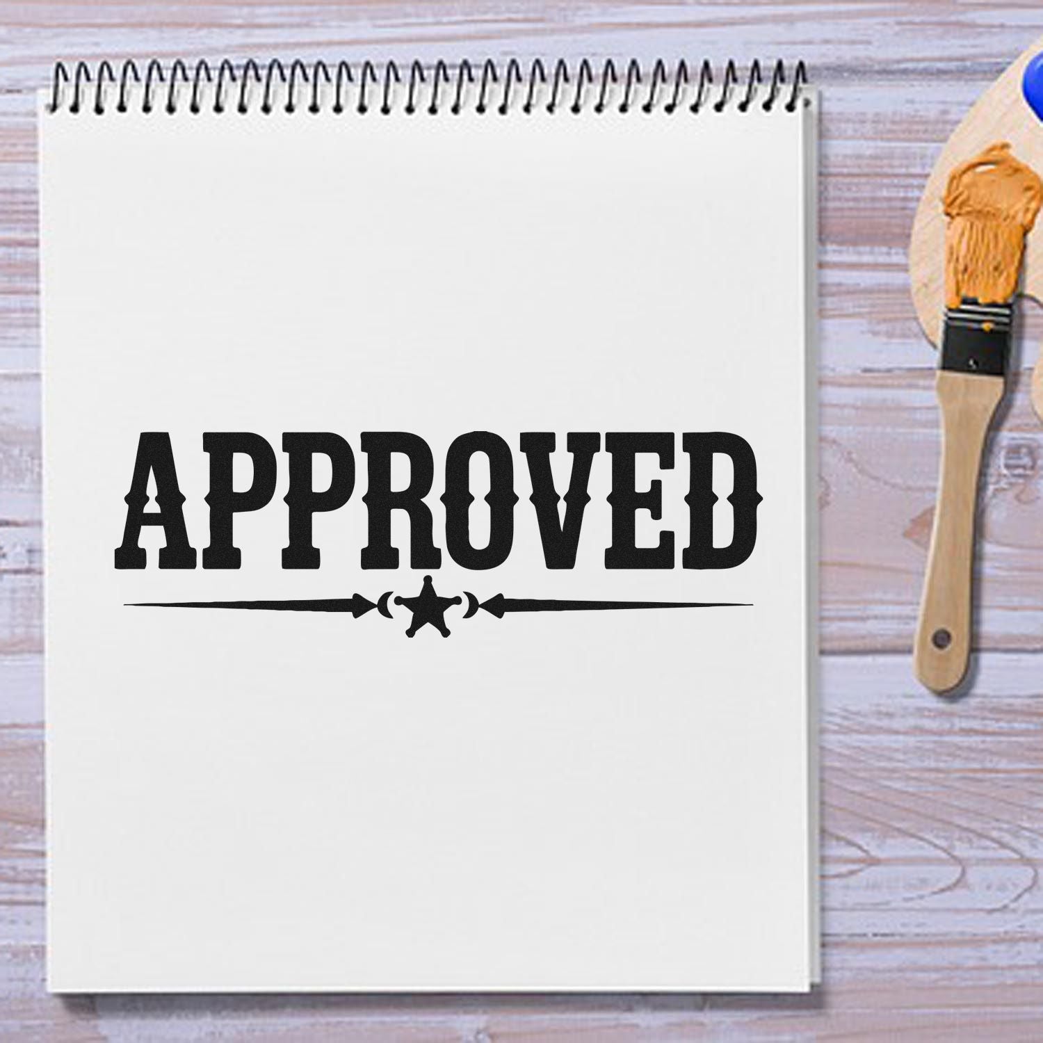 Approved rubber stamp impression on a notebook page, with paintbrush, for office, craft, and custom stamp branding.