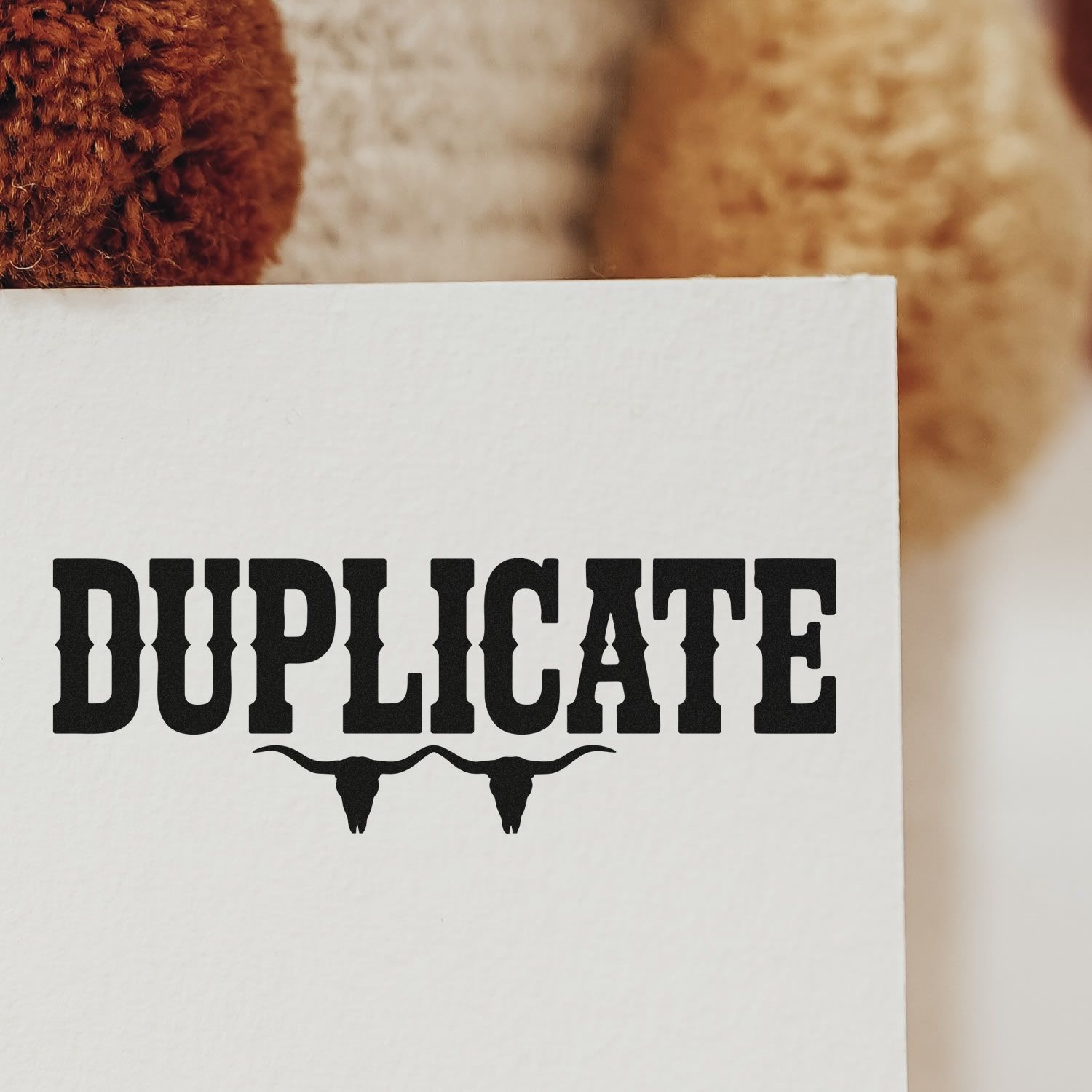 Duplicate rubber stamp impression on paper with bold western-style lettering and longhorn skull design.