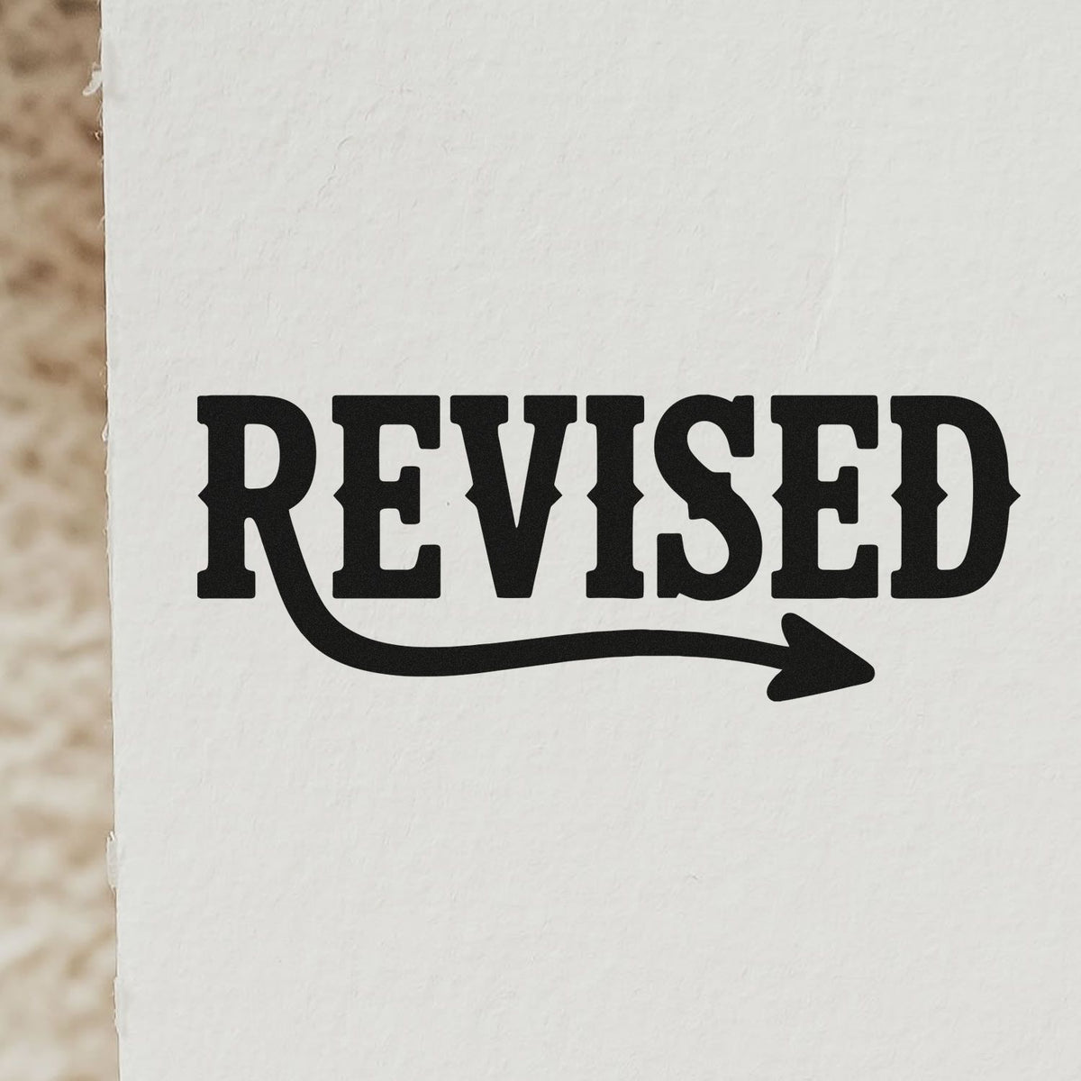 Revised rubber stamp design with bold arrow underline for document updates, approvals, and office paperwork.