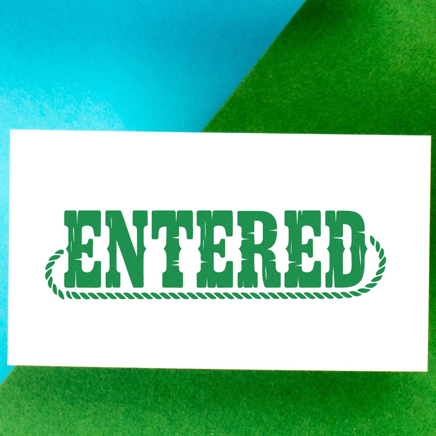 Green ENTERED rubber stamp on paper for document processing, record keeping, and office approval.