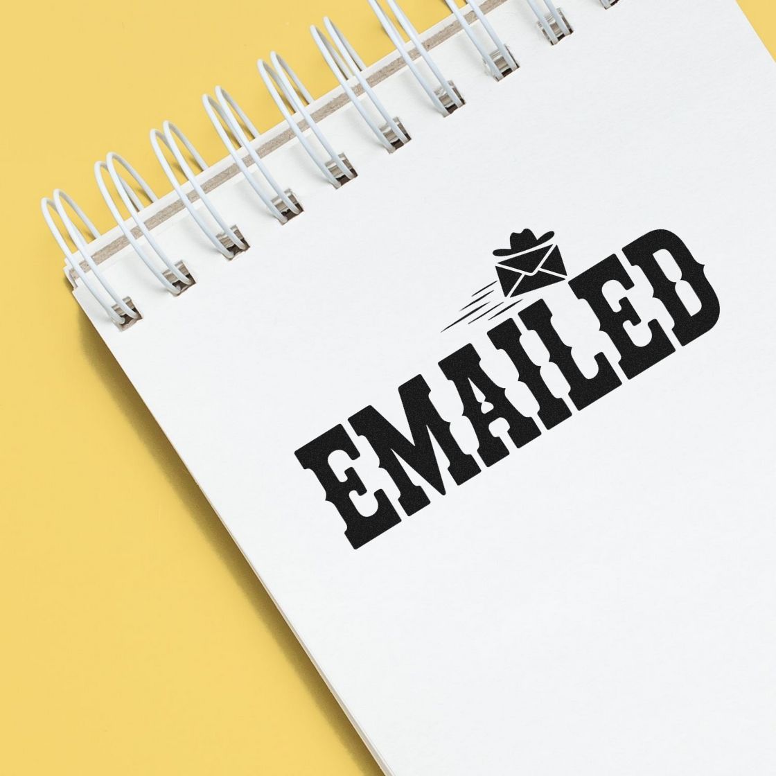 Emailed rubber stamp impression on notebook page, ideal for office mail processing and business document tracking.