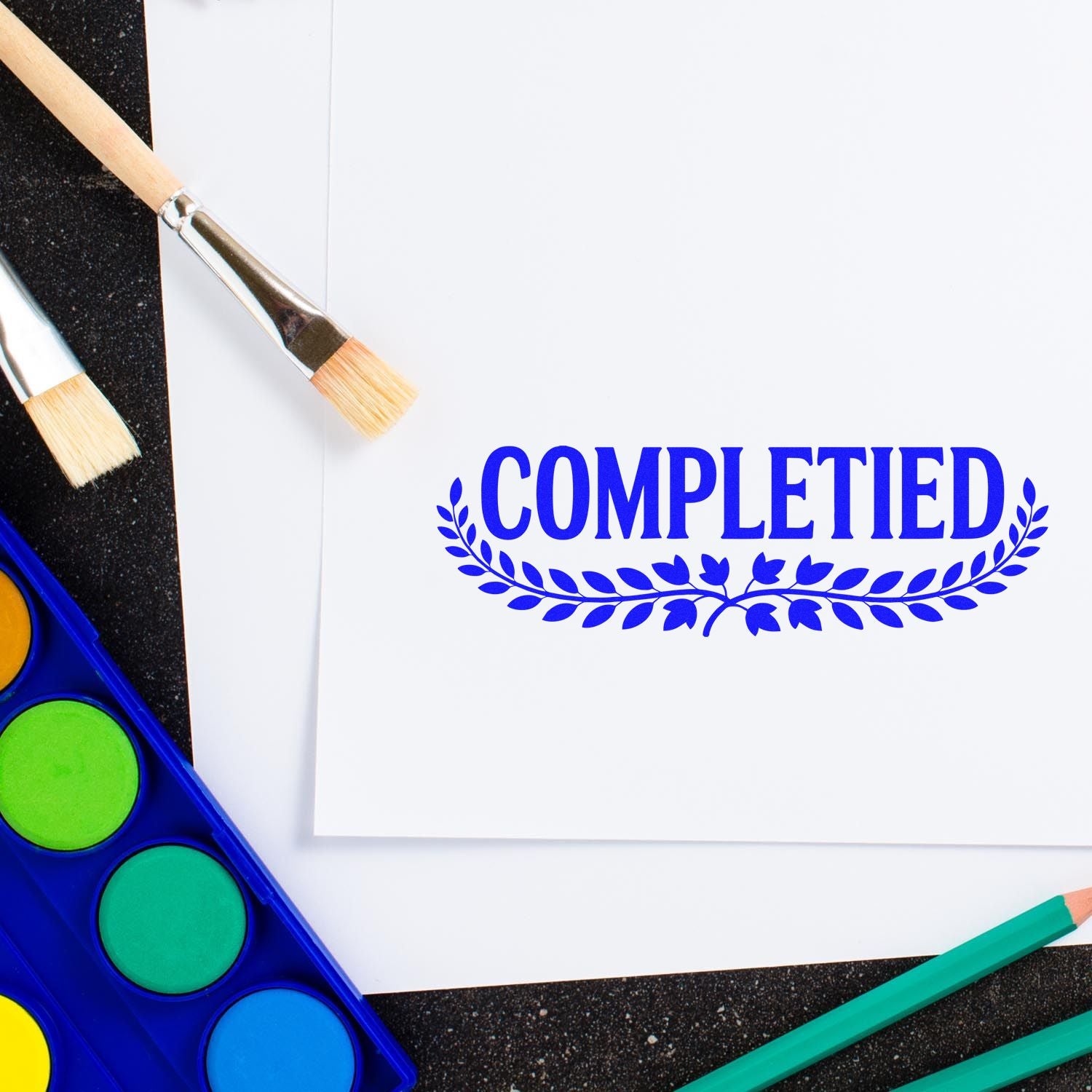Completed rubber stamp design on paper with art supplies, perfect for marking finished projects.