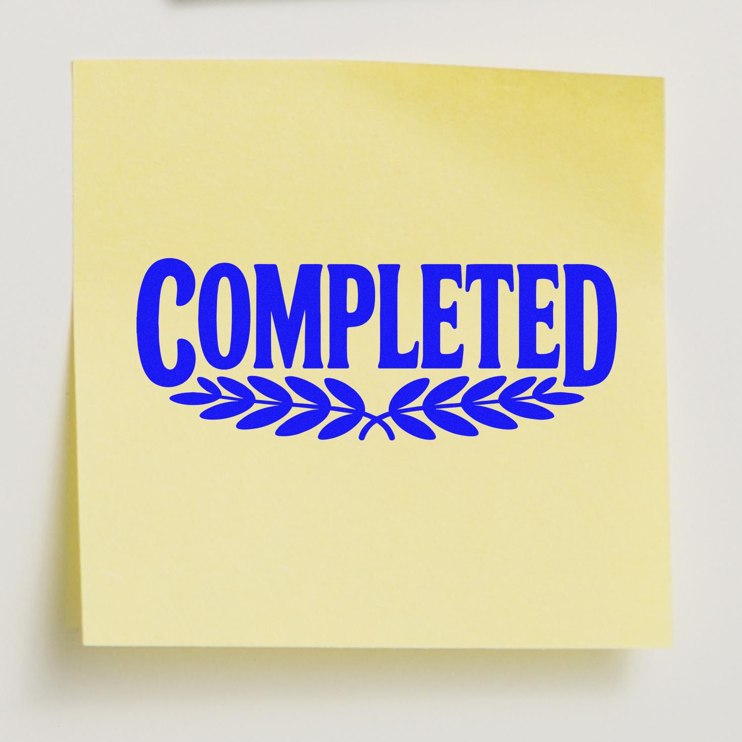 Blue COMPLETED rubber stamp on sticky note, used to mark a finished task or project status.