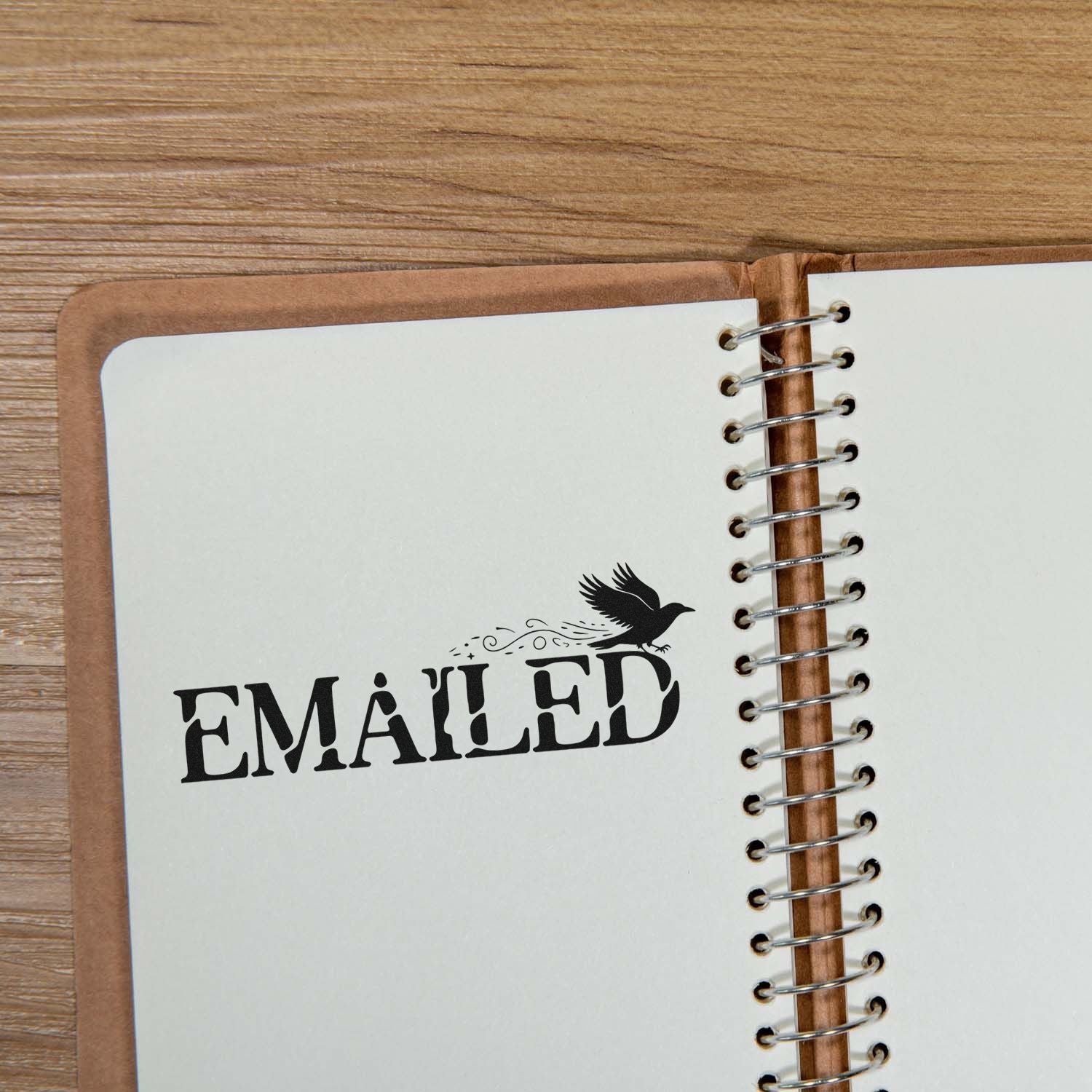 EMAILED rubber stamp with crow graphic stamped on an open spiral notebook page