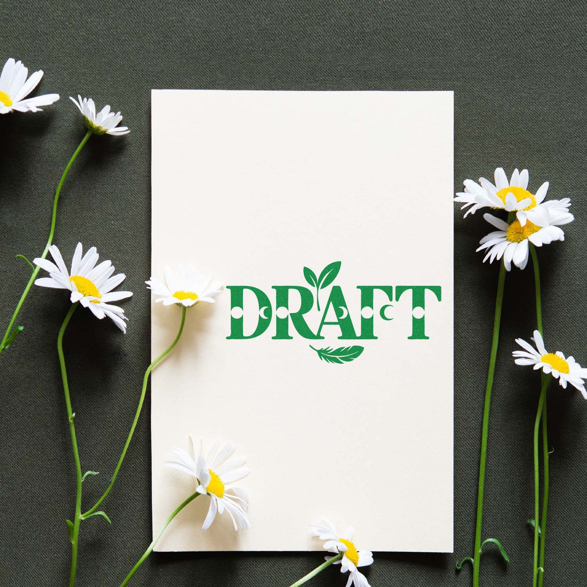 Green DRAFT rubber stamp design on white card with daisies, ideal for handmade stationery and craft projects.