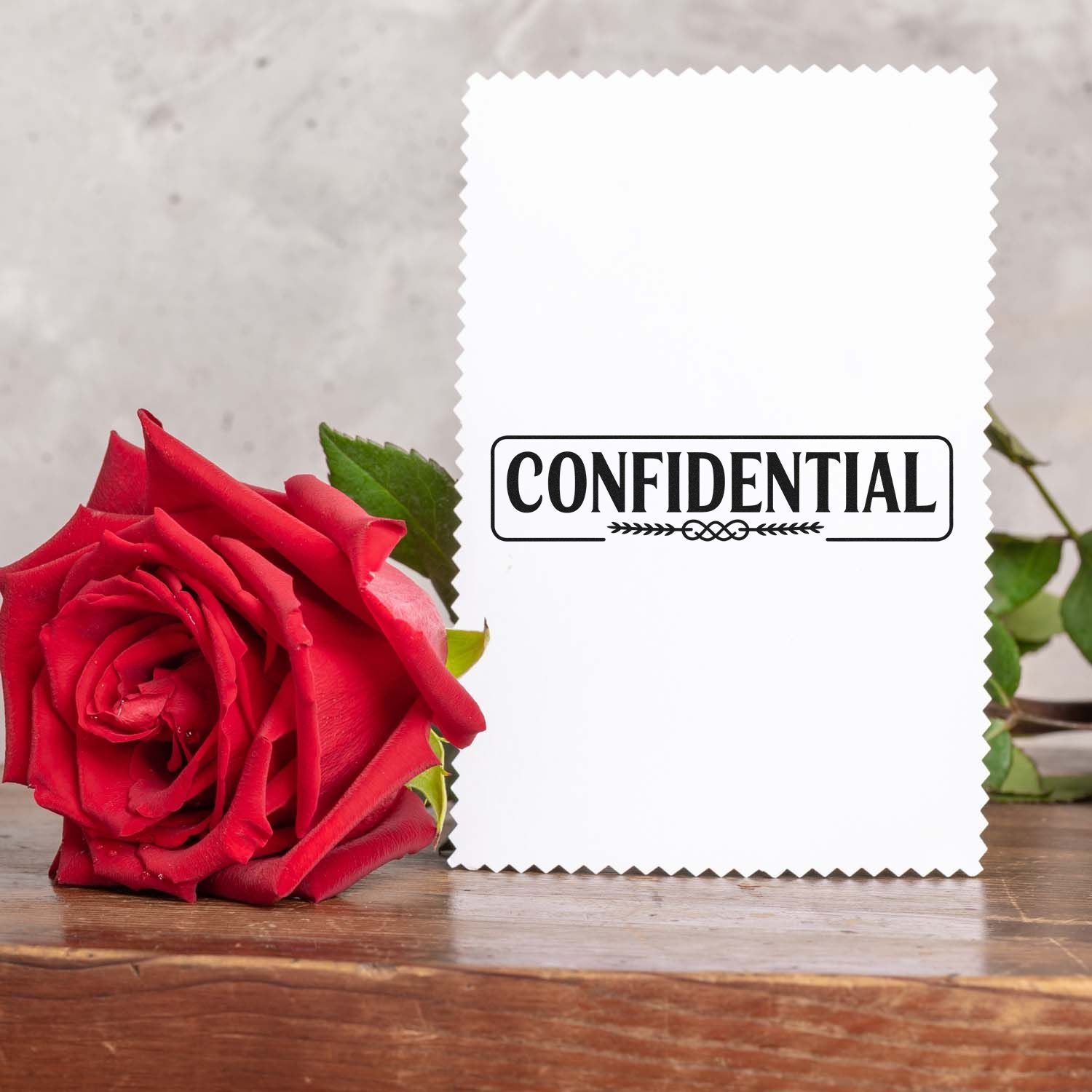 Confidential rubber stamp on white card with red rose, ideal for marking private documents and envelopes.
