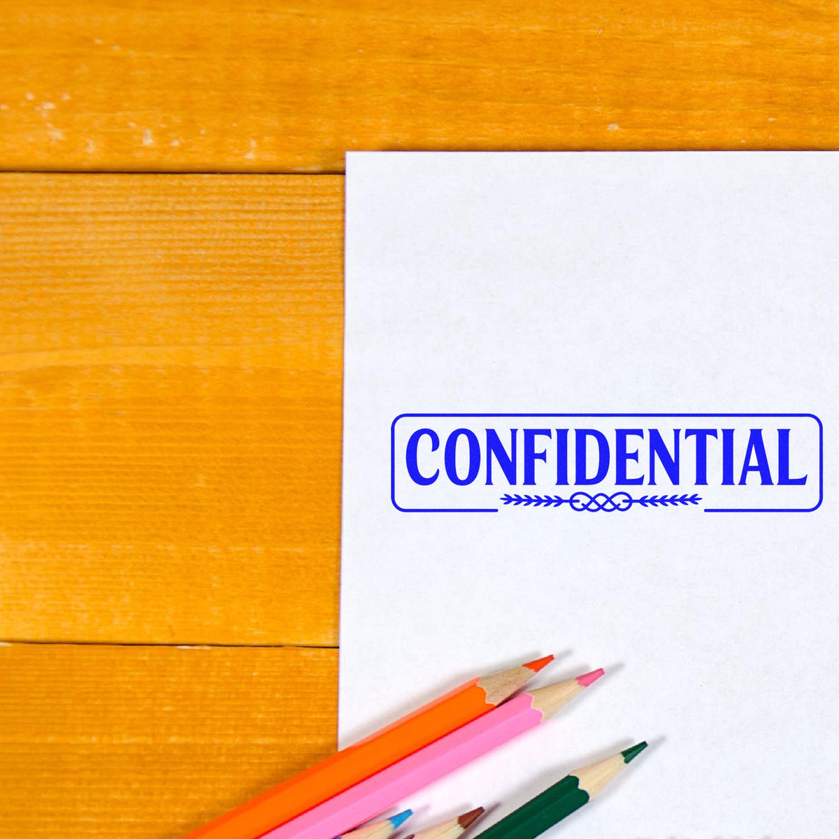 Confidential rubber stamp on document with colored pencils on wooden desk, used for office mail and paperwork.